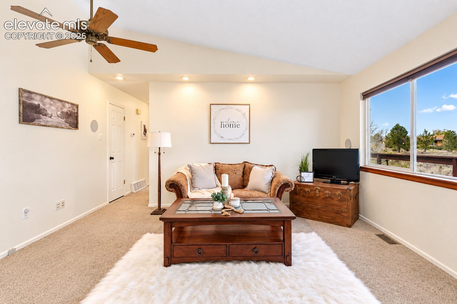 Vaulted ceiling featuring a central wood-finish ceiling fan and recessed lighting