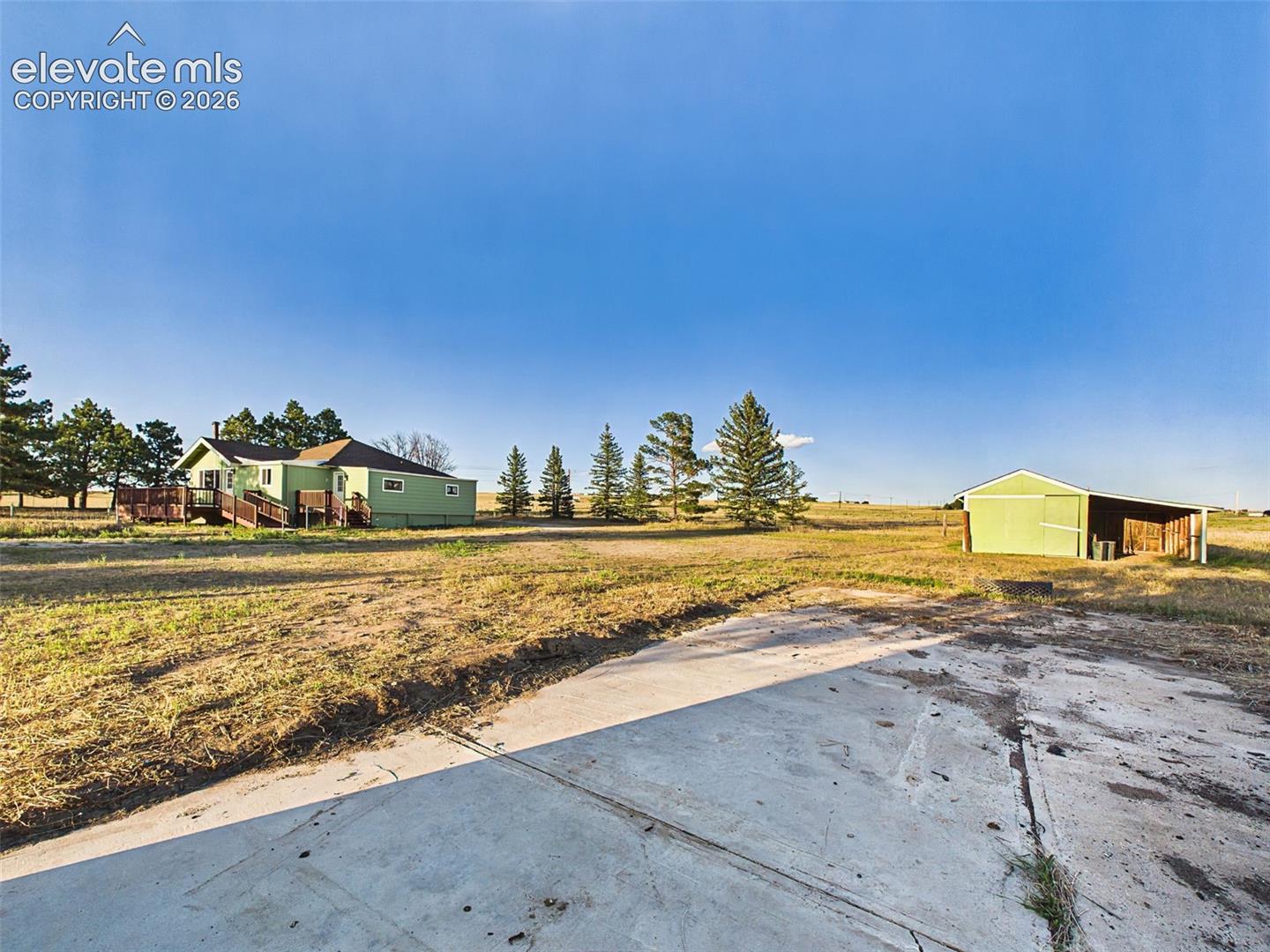 Concrete Slab – Spacious concrete slab remains in place from a previous structure, providing a solid foundation for a potential future outbuilding or workshop.