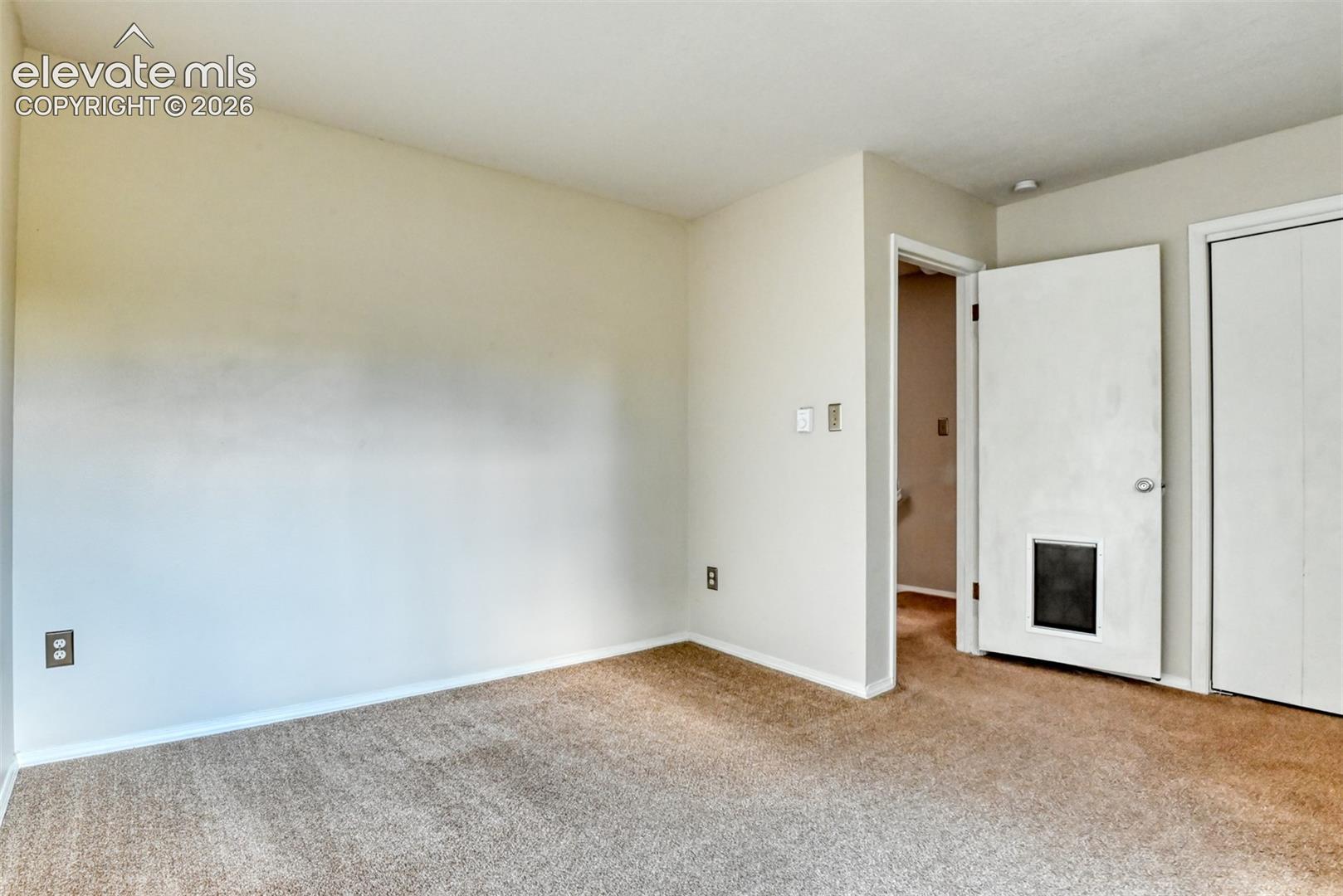 Wall-to-wall carpeting with light-toned walls and white trim