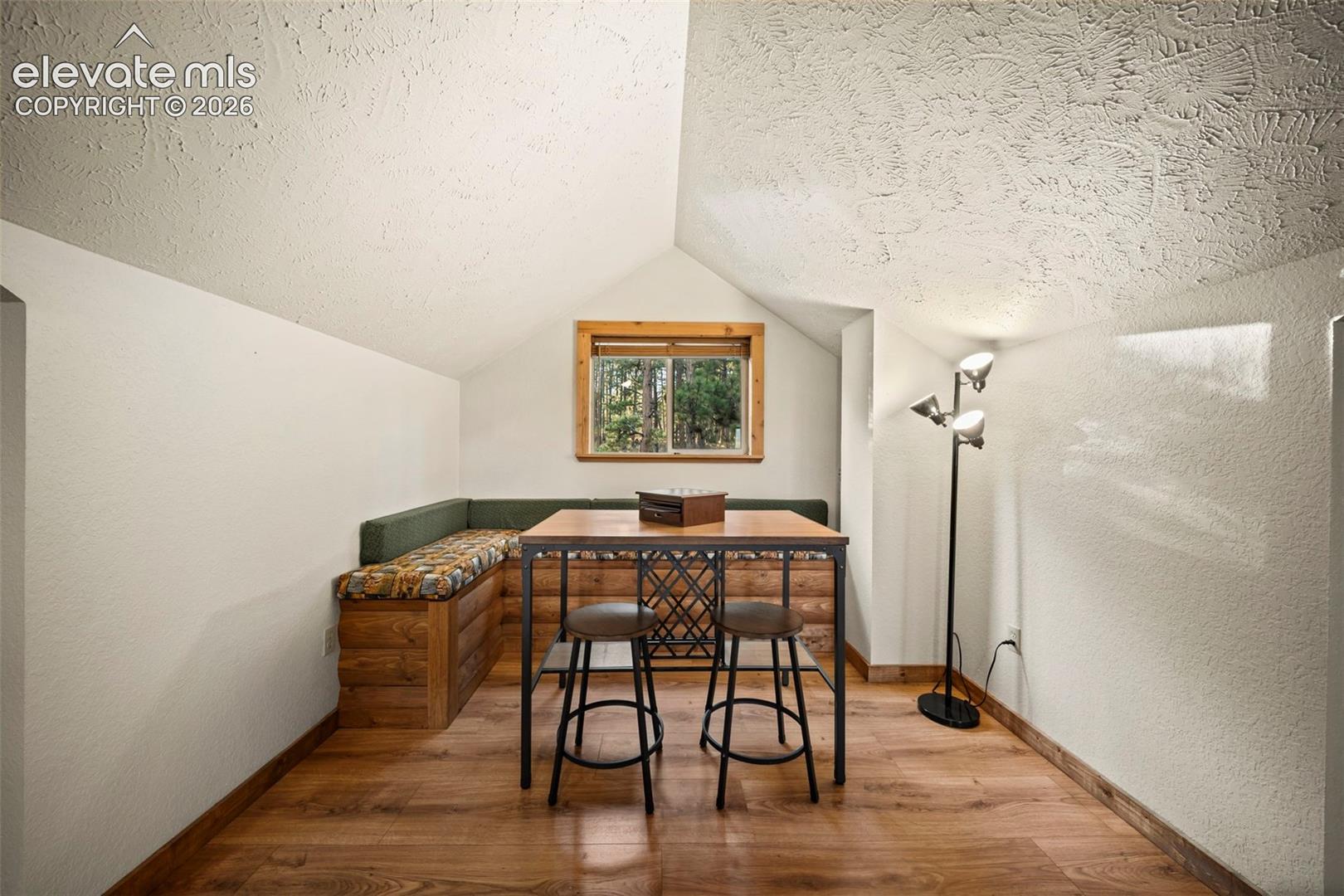 Built-in wood bench seating featuring natural wood-finish construction, vaulted ceiling with textured finish, and wood-finish flooring
