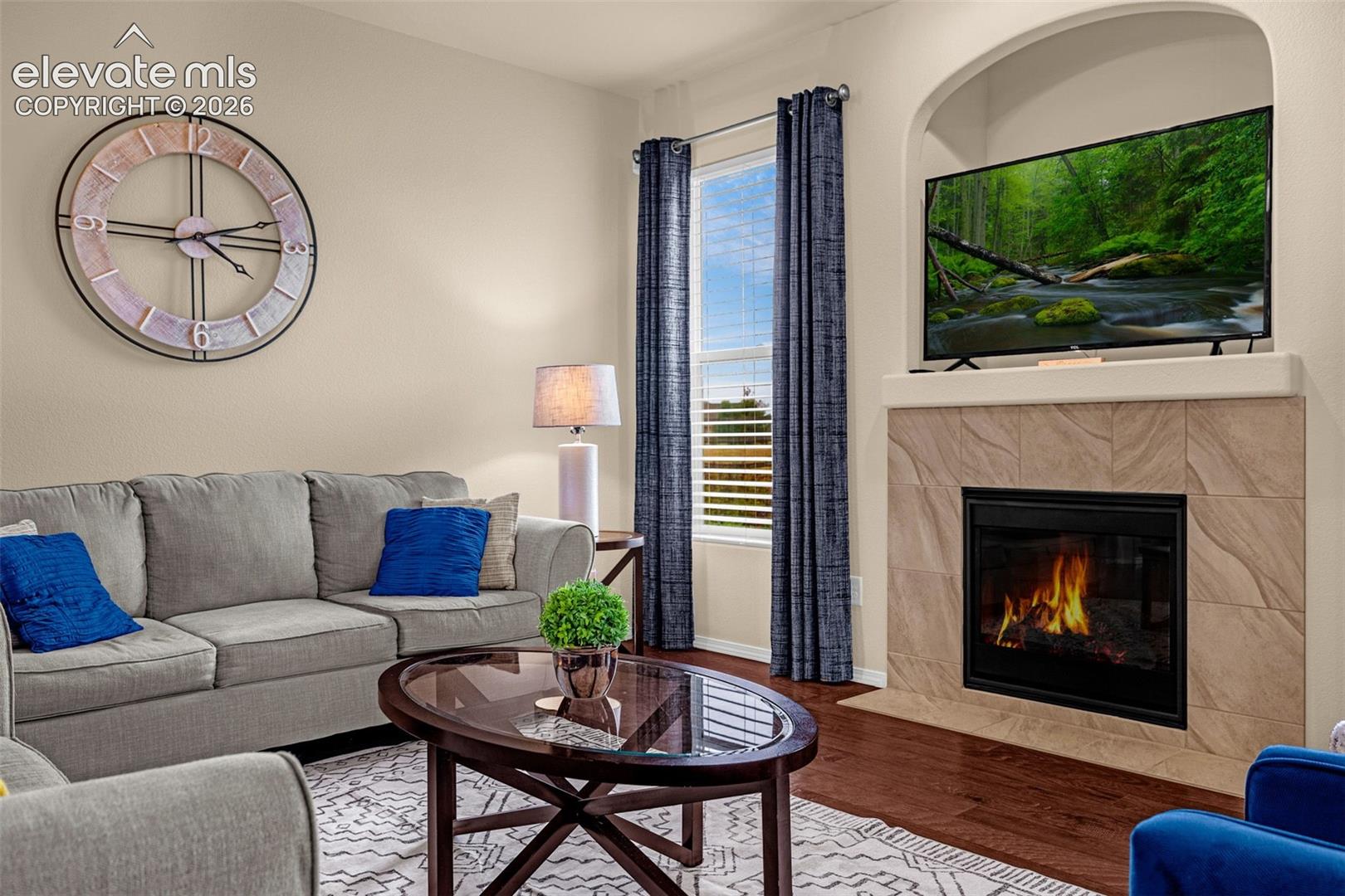 Fireplace featuring a stone-tile surround, arched built-in recessed niche, and wood-finish flooring