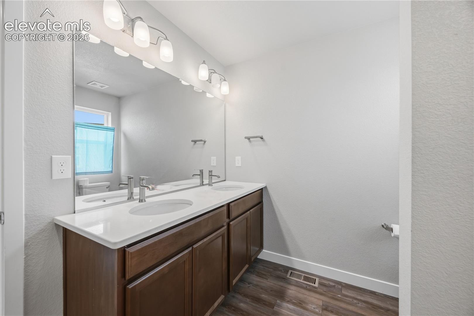 Comfort height, dual sink vanity and mirror in the upper level Hall Bathroom.