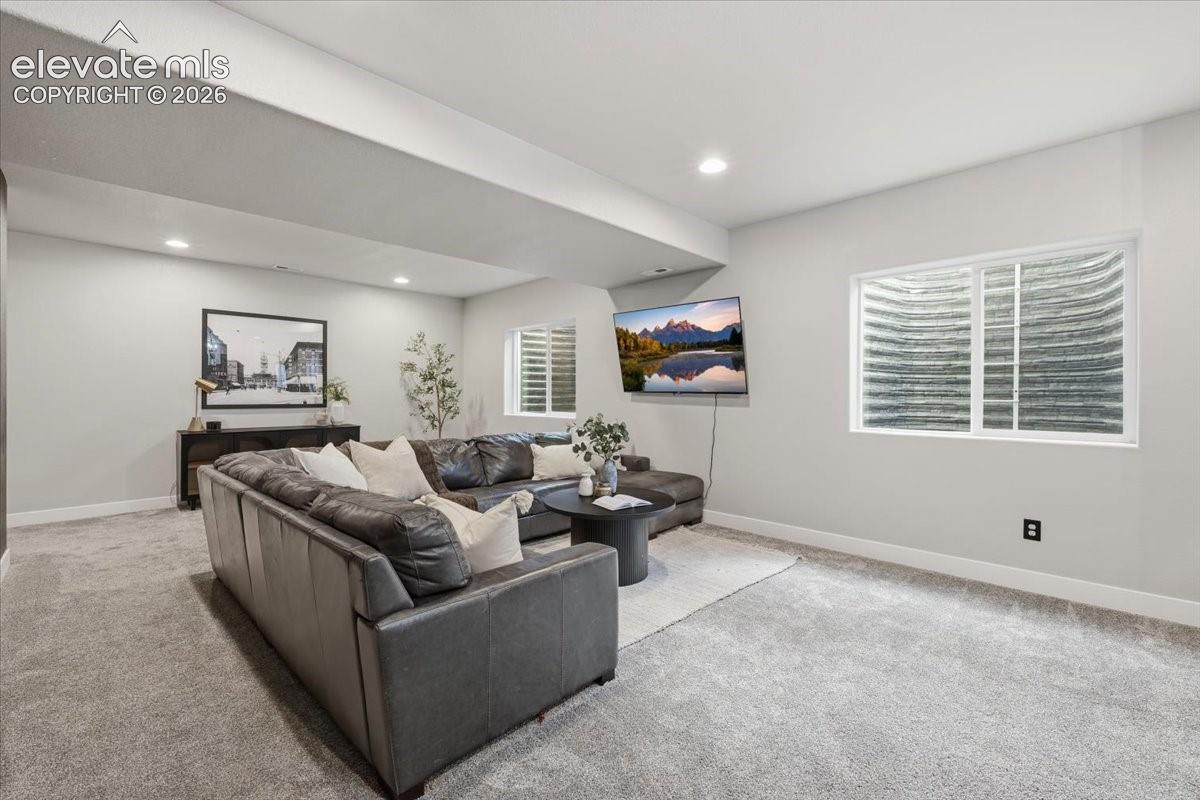Recessed lighting, wall-mounted television, and a window with blinds