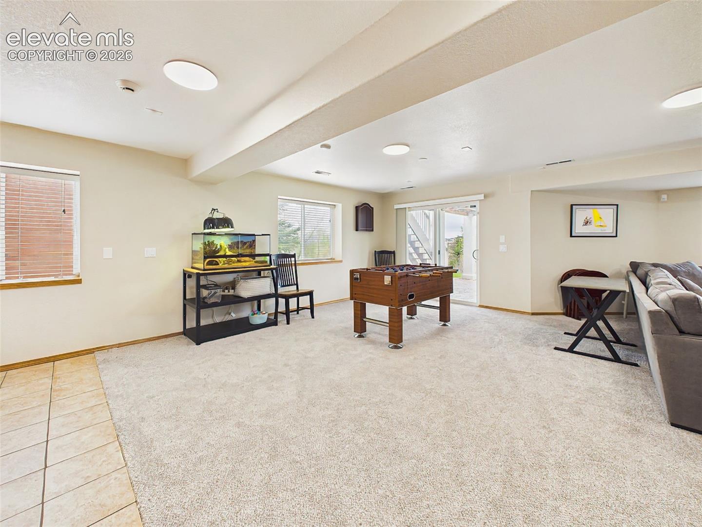Spacious walkout recreation area with plush carpeting and ample room for games, gatherings, or movie nights.