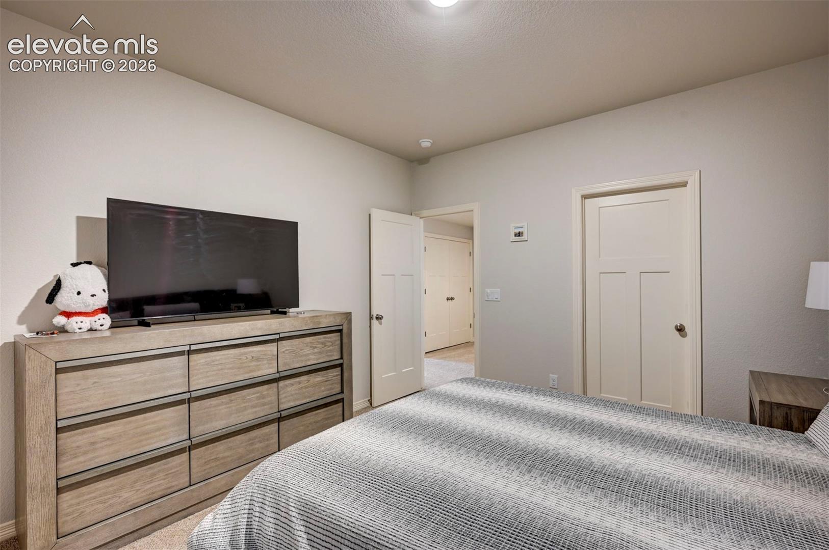 Bedroom featuring neutral wall paint, white trim, and a ceiling light fixture