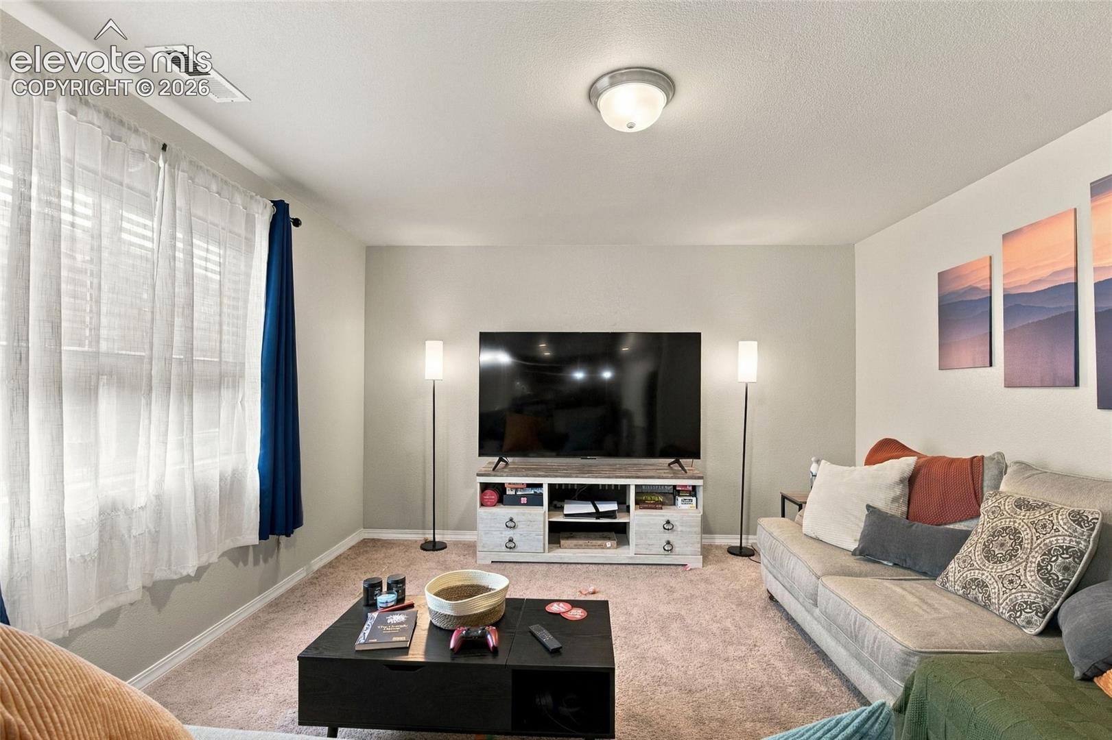 Neutral-toned interior space featuring wall-to-wall carpeting and a ceiling-mounted dome light fixture
