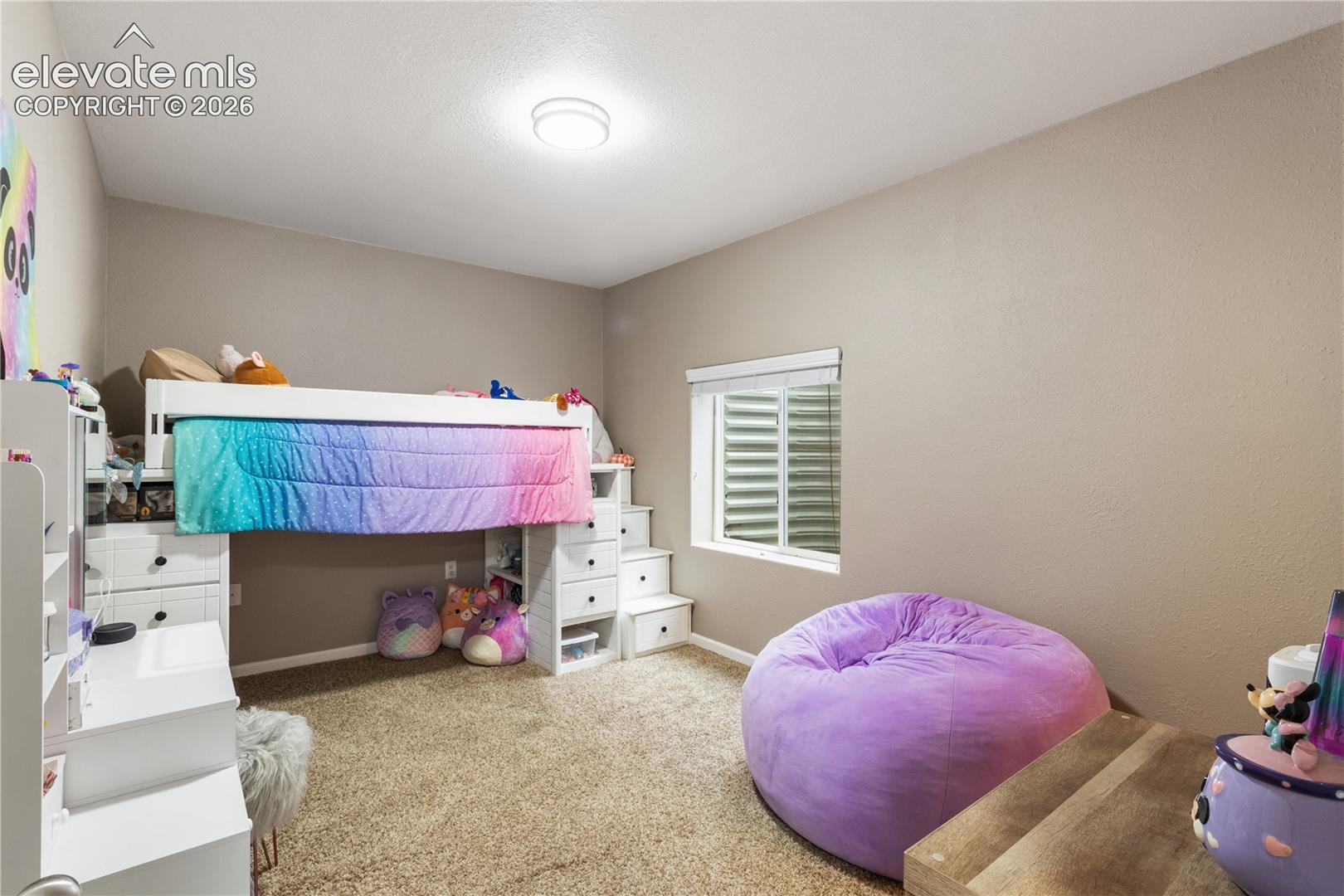 Neutral interior featuring wall-to-wall carpeting and a recessed window with a well-integrated egress window well