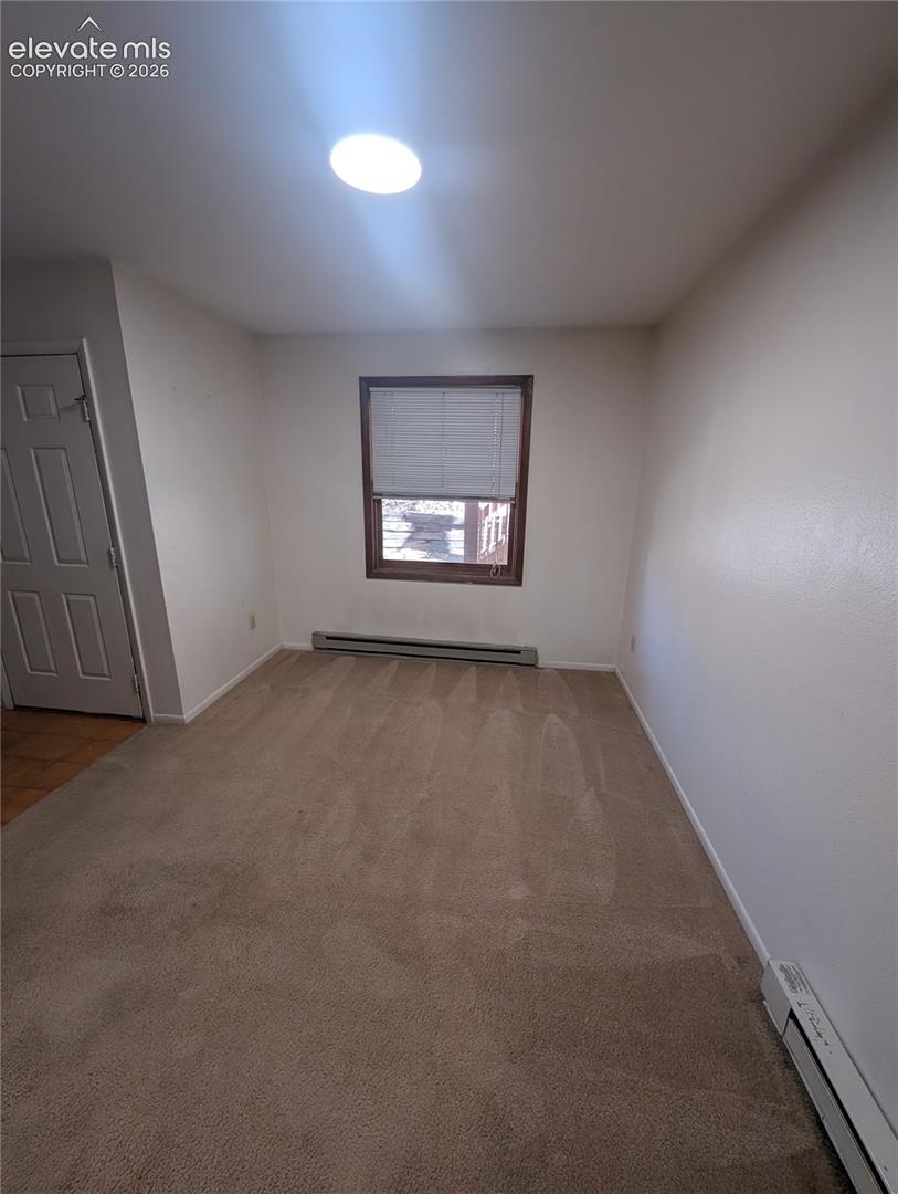Recessed ceiling lighting, wood-framed window, baseboard heating units, and wall-to-wall carpeting