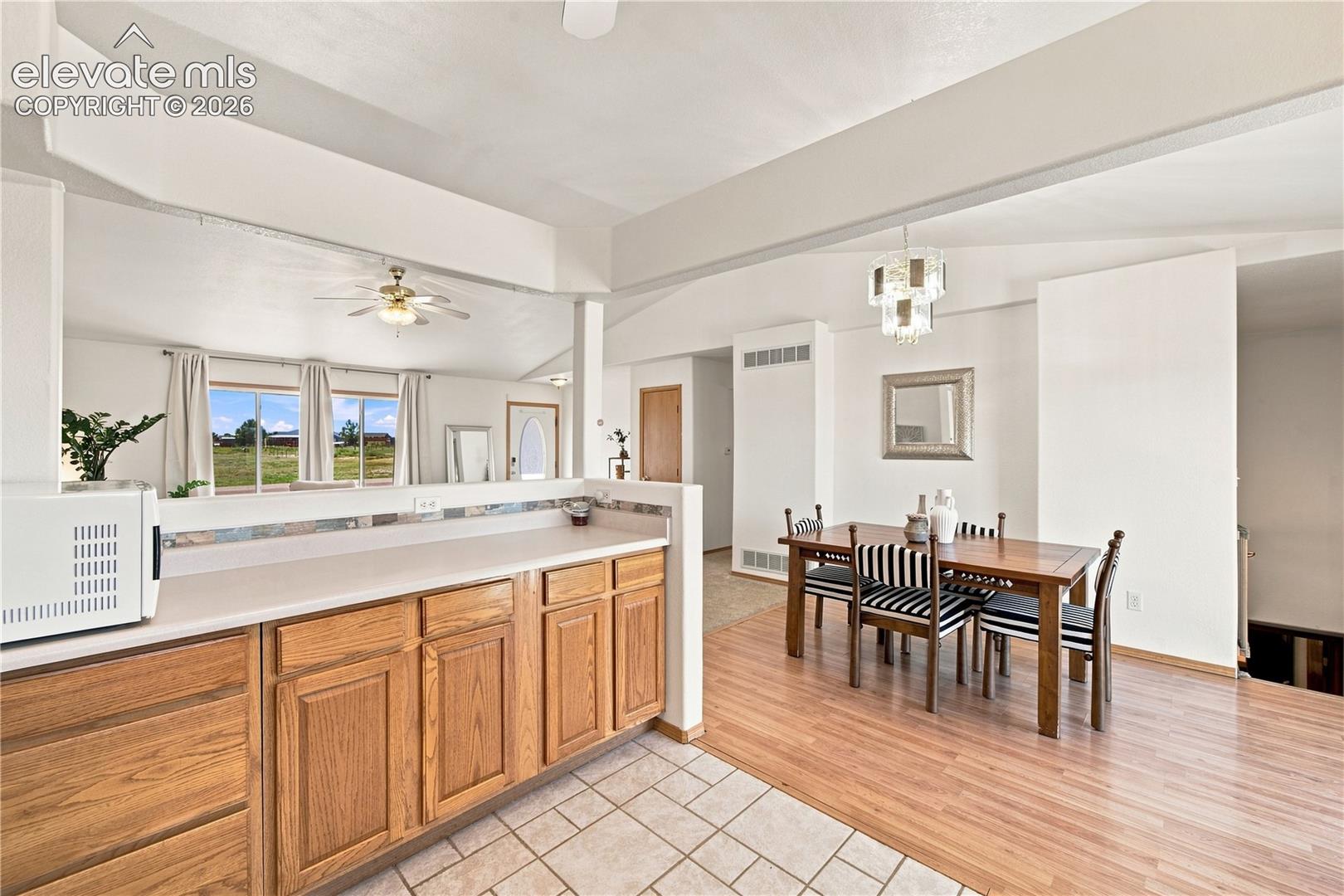 Kitchen featuring wood-finish cabinetry, light-toned countertops, and tile flooring