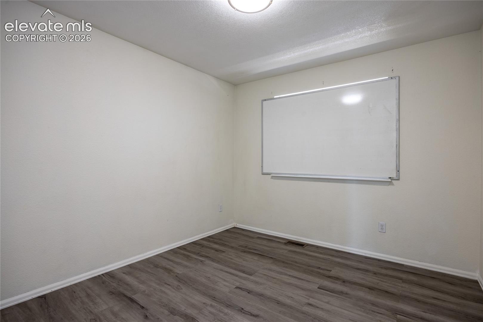 Recessed lighting illuminating the room with wood-finish flooring