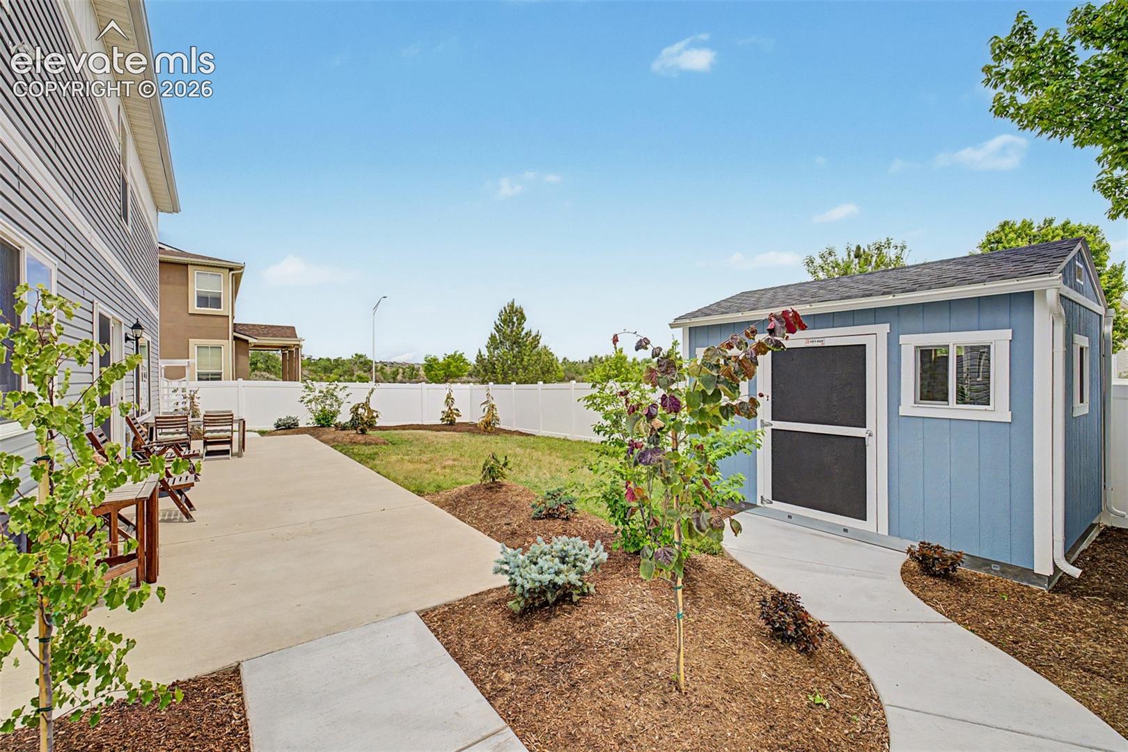 The fully fenced backyard is a true blank canvas, with a concrete patio, fresh landscaping, a storage shed, and open lawn space just waiting to be shaped into something extraordinary.