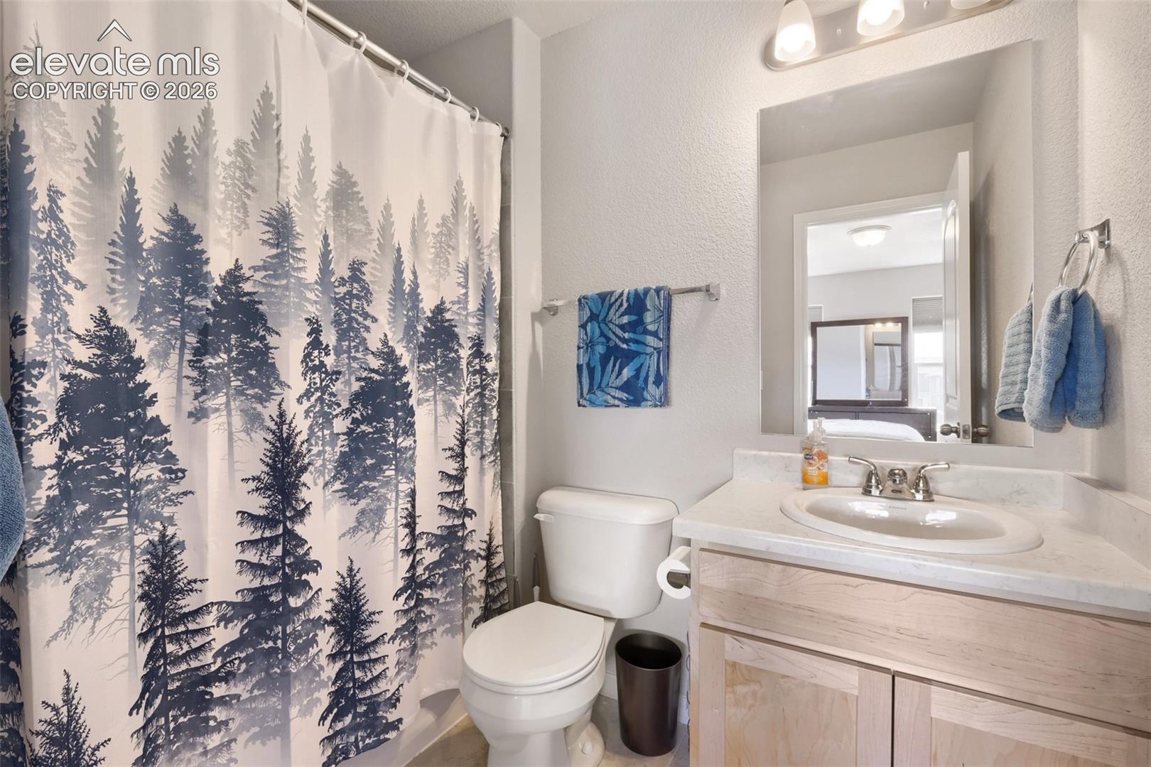 Bathroom featuring a single-sink vanity with light wood-finish cabinetry and a white countertop