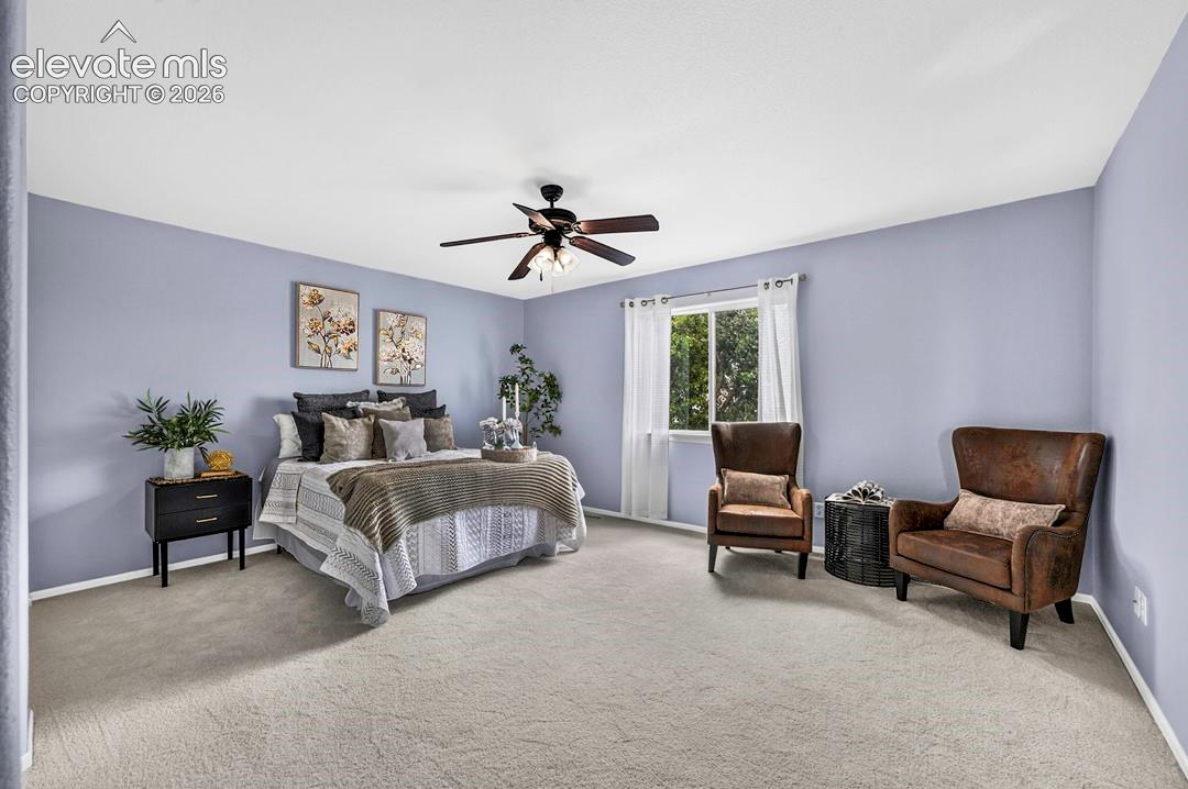 Spacious room featuring neutral wall-to-wall carpeting and a central ceiling fan with integrated lighting