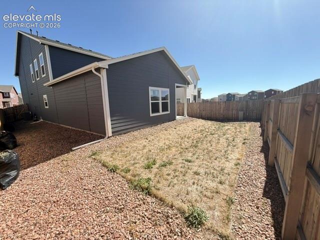 Exterior featuring horizontal siding, white trim, and a fenced perimeter