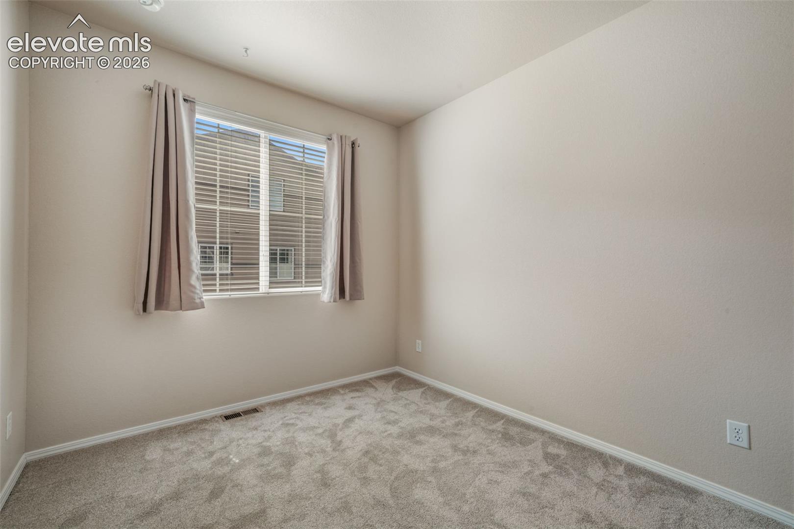 Broadloom carpet flooring, neutral paint palette, recessed ceiling lighting, and a single window with blinds