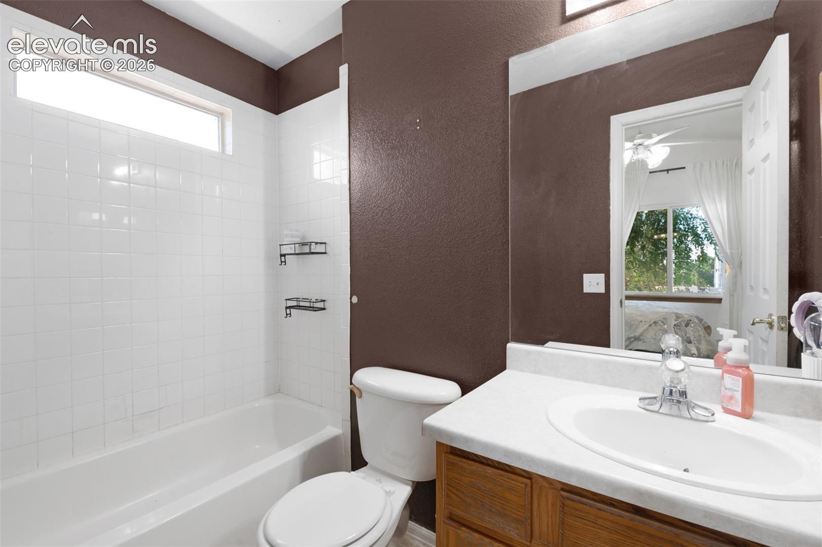 Bathroom featuring a white subway tile tub surround with a transom window