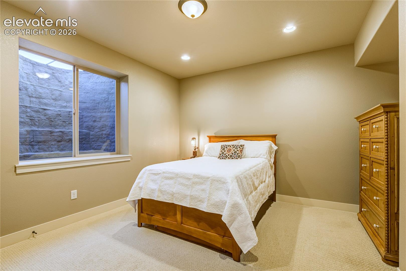 An additional garden-level bedroom provides flexible accommodations for guests, hobbies or a private retreat, with a large window, neutral finishes + the versatility to adapt to changing needs.