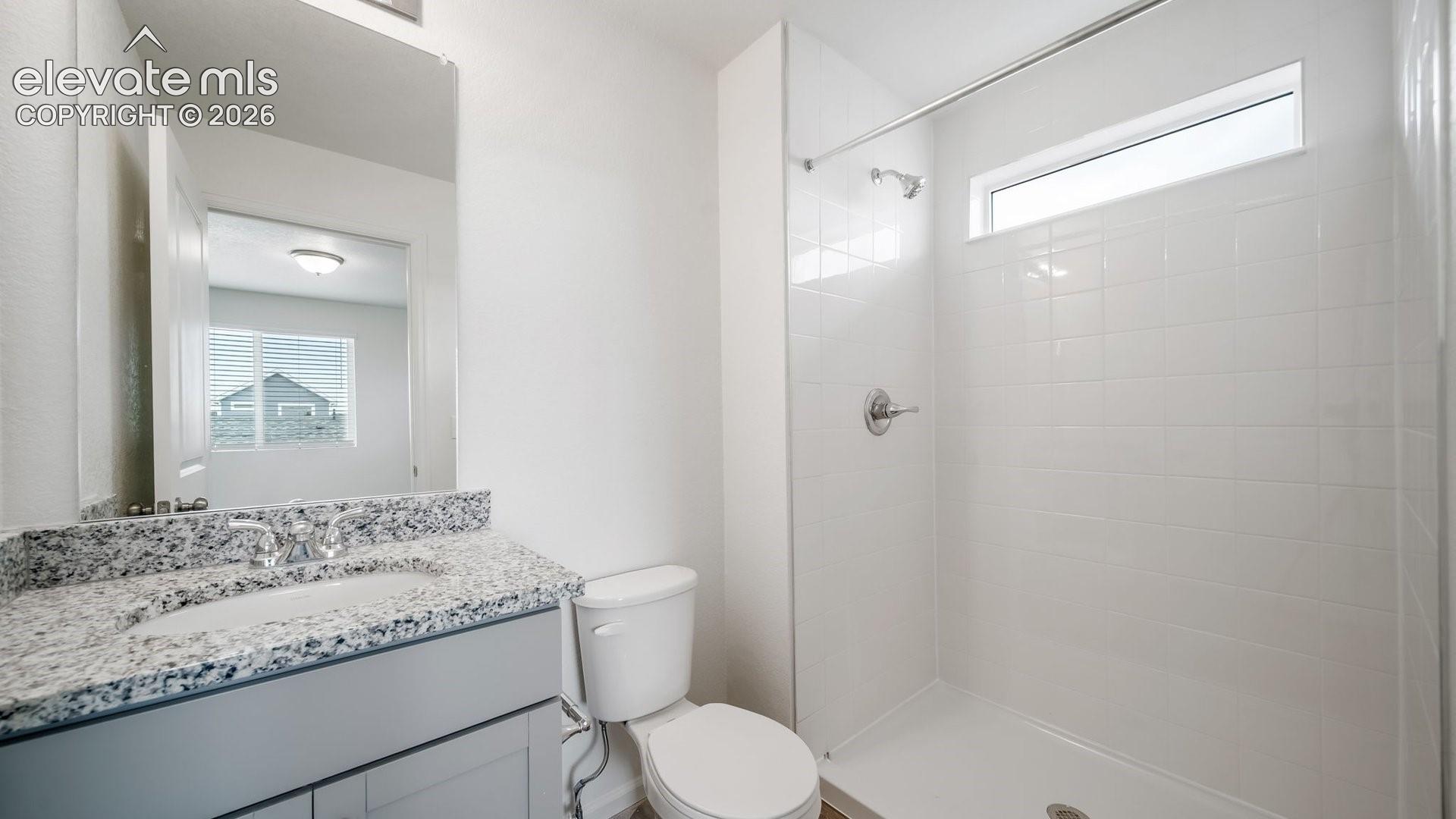 Vanity with a granite countertop, undermount sink, and chrome faucet
*photos of a model home*