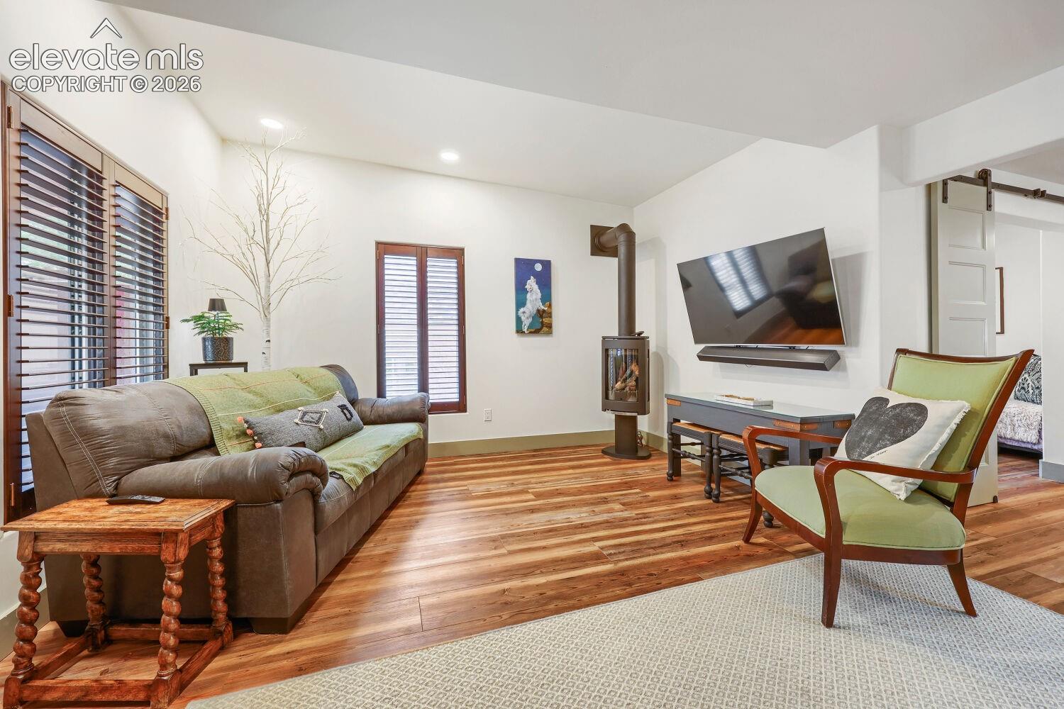 Wood-finish flooring, recessed lighting, and a modern wood-burning stove