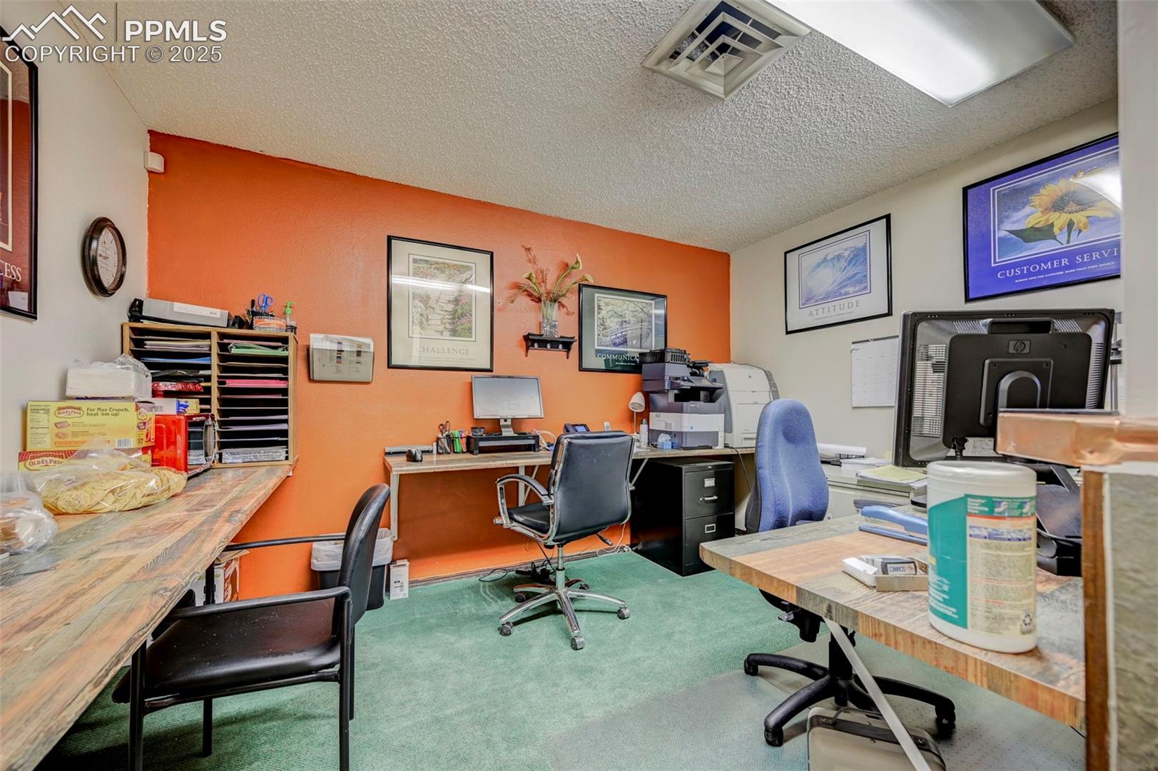 Carpeted office space featuring a textured ceiling
