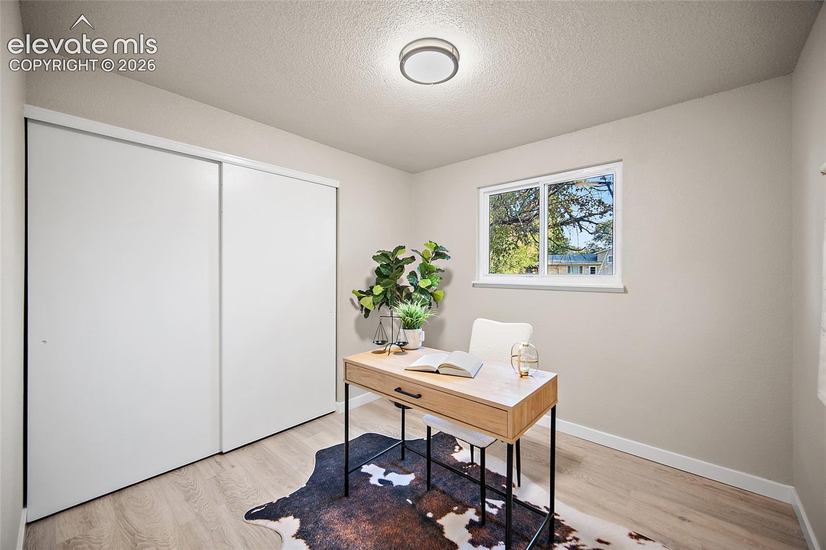Recessed lighting, wood-finish flooring, white sliding closet doors, and a window with a white frame