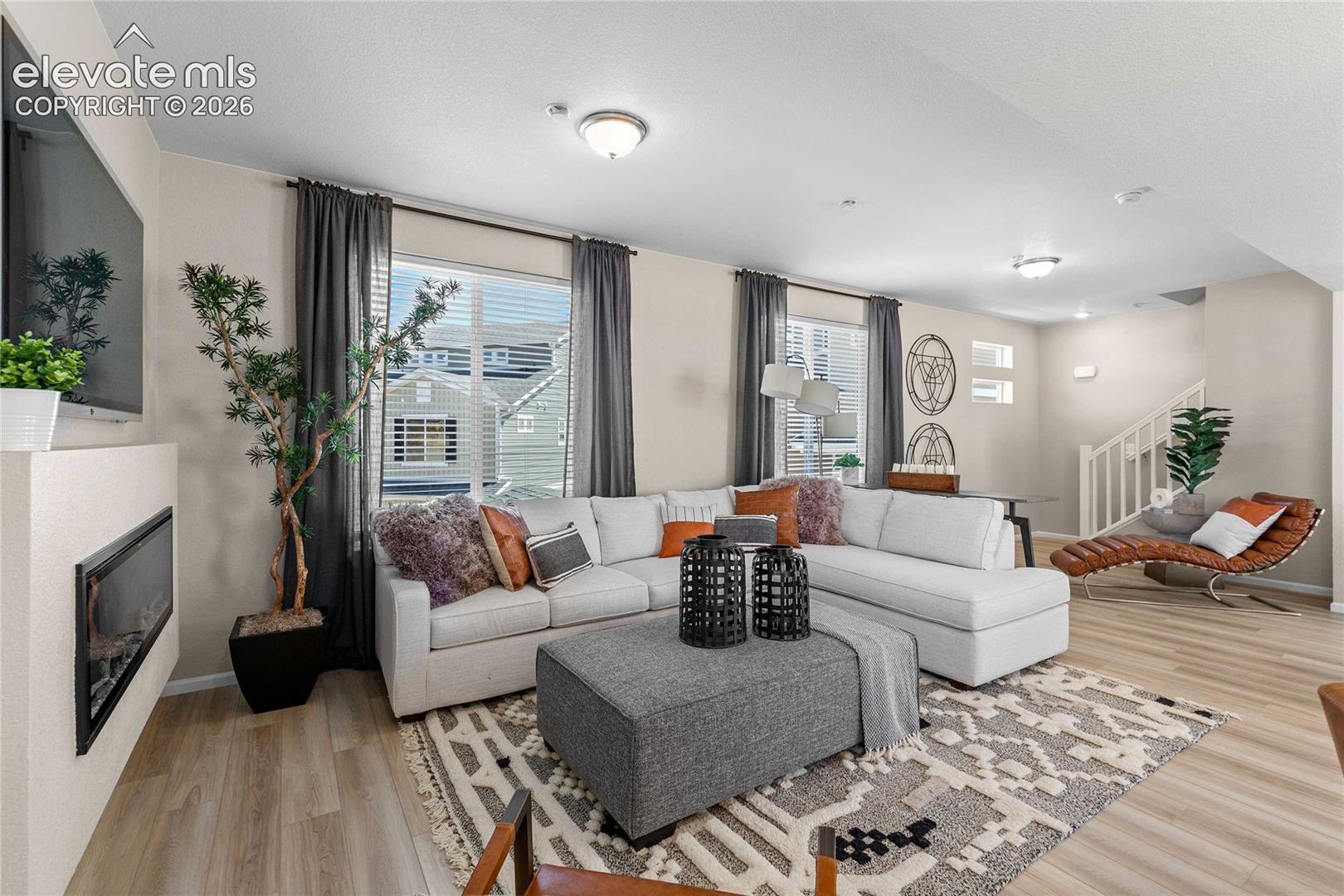 Spacious living area featuring wood-finish flooring, recessed lighting, and large windows
*photos of a model home*