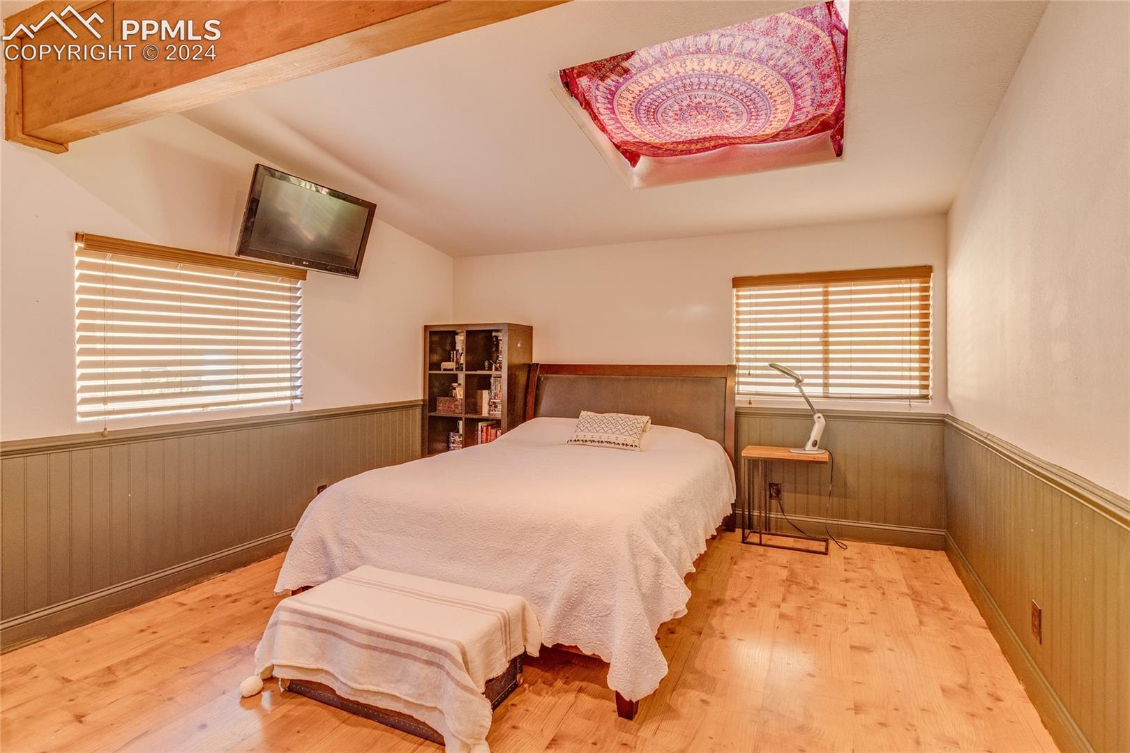 Bedroom featuring lofted ceiling and light wood-type flooring