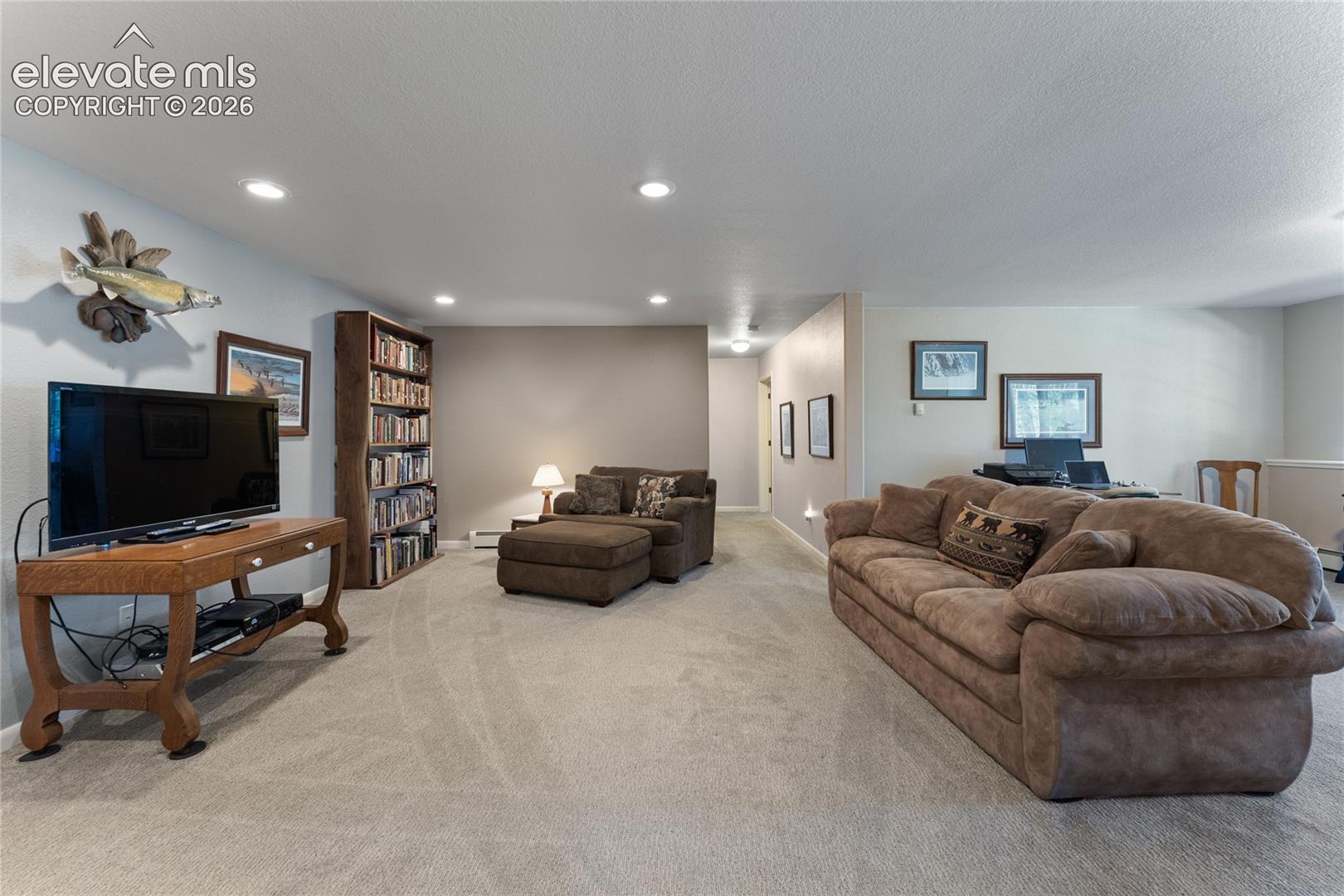 Carpeted living space featuring recessed lighting and neutral wall tones