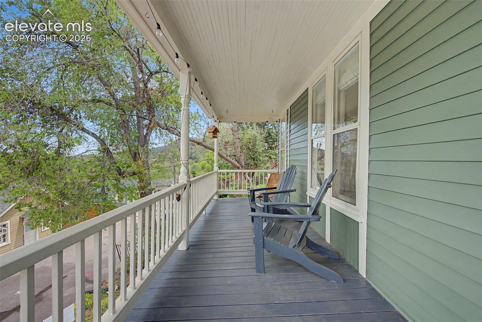 Covered porch overlooking road with red rock and mountain views