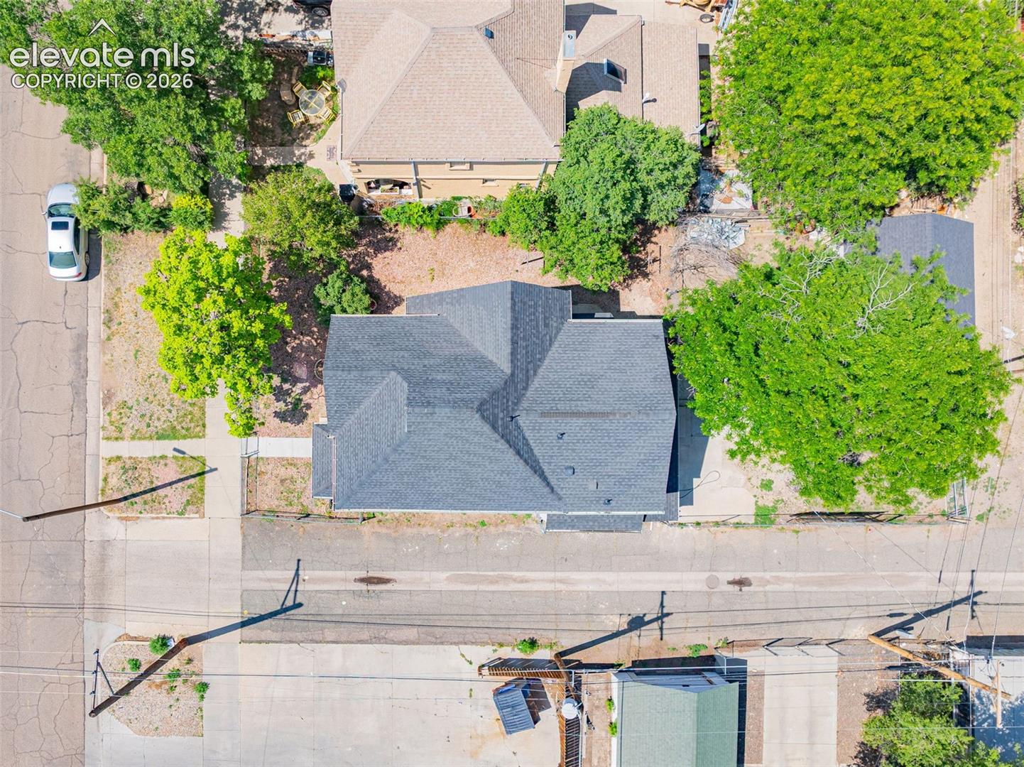 Gabled roofline with dark shingles, set on a lot with mature trees and established landscaping