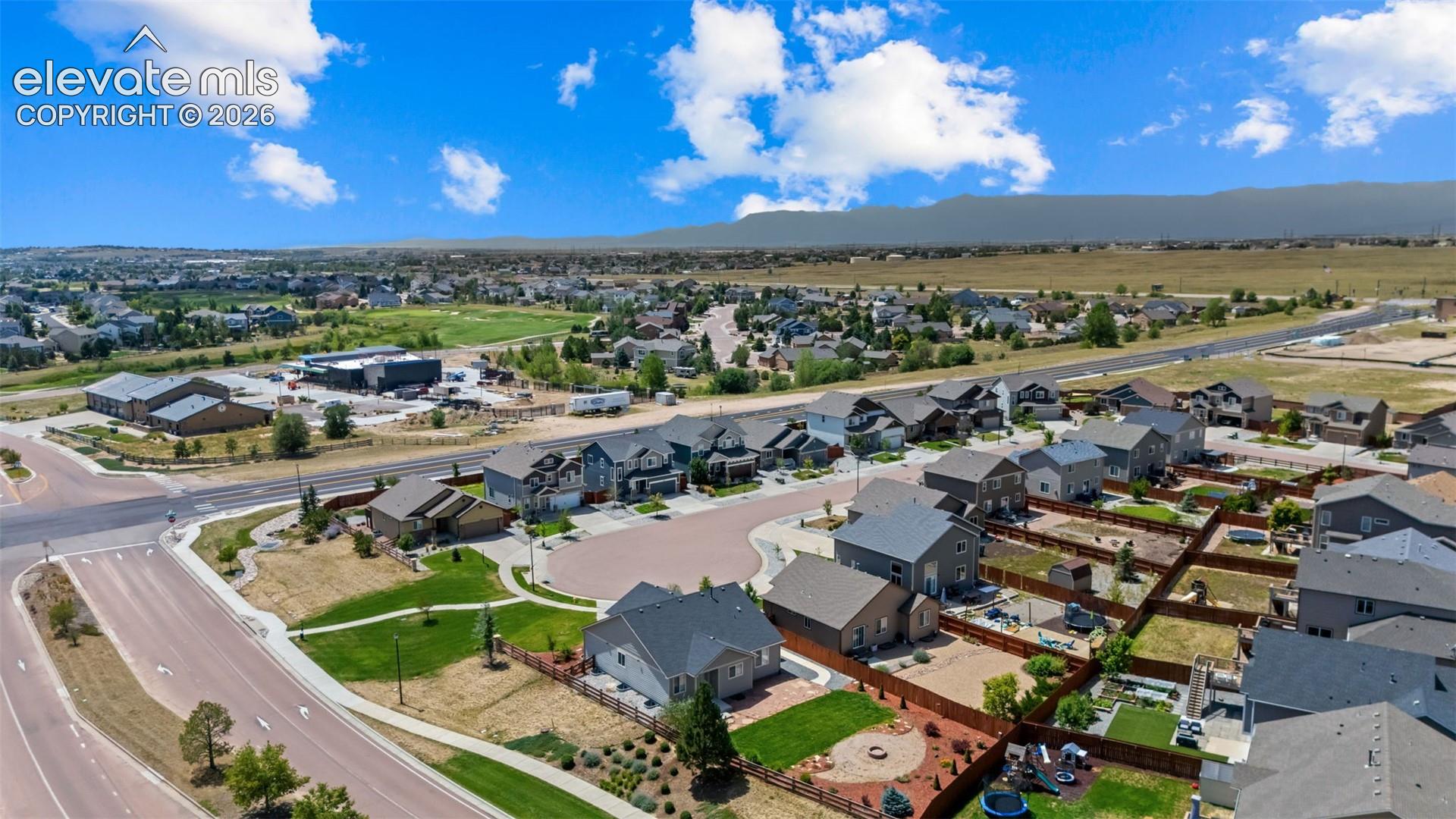 Aerial view of a new residential community featuring multiple contemporary homes with modern architectural design, manicured landscaping, and paved streets