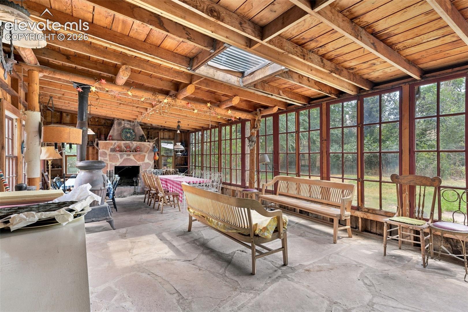 Enclosed porch with flagstone floors and large wood burning fireplace
