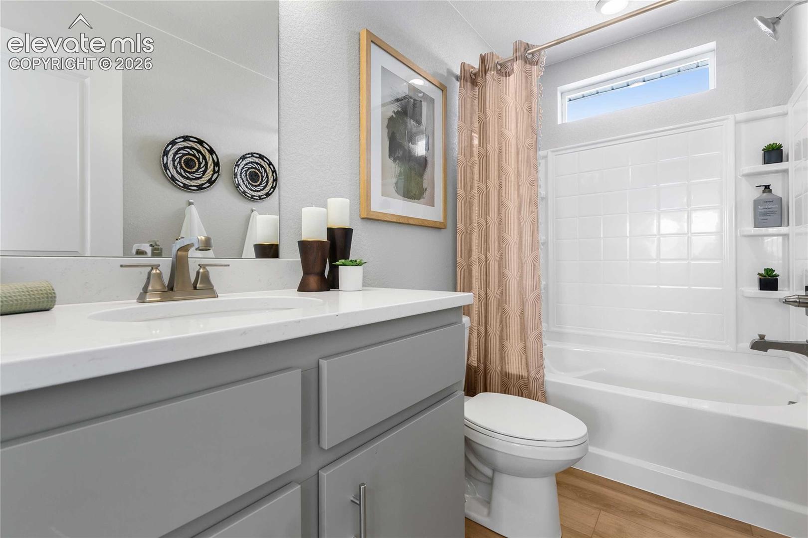 Spa-inspired bathroom featuring a gray vanity with dual sinks, white quartz countertop, and polished chrome fixtures
*photos of a model home*