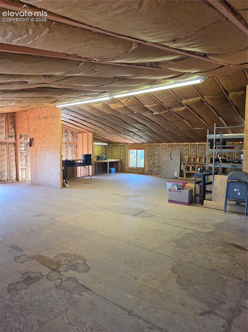 Open-concept interior with plywood flooring and framed walls