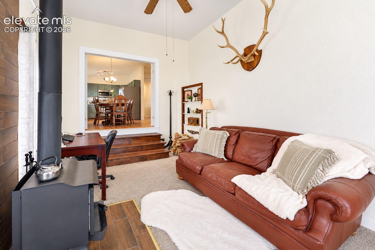 Freestanding wood-burning stove on a tile hearth, wood-finish wall accent, and wood-finish multi-level steps