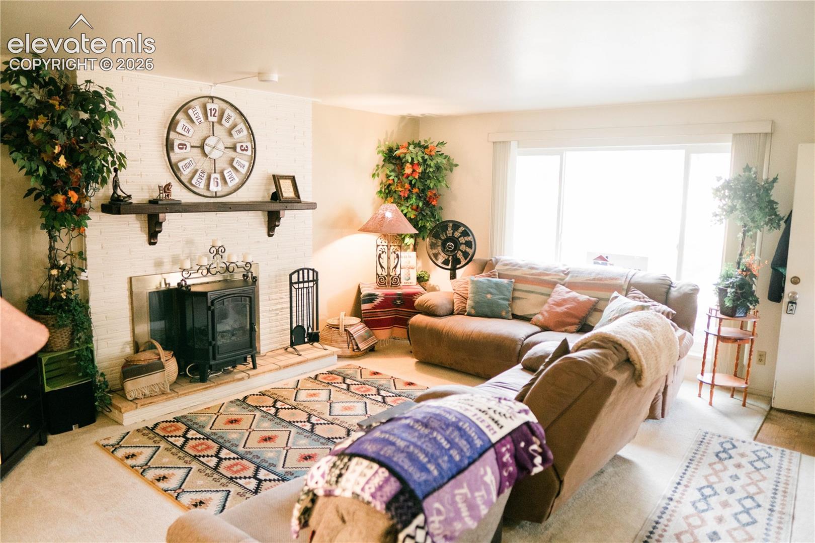 White painted brick fireplace with a dark wood mantel and a wood-burning stove insert