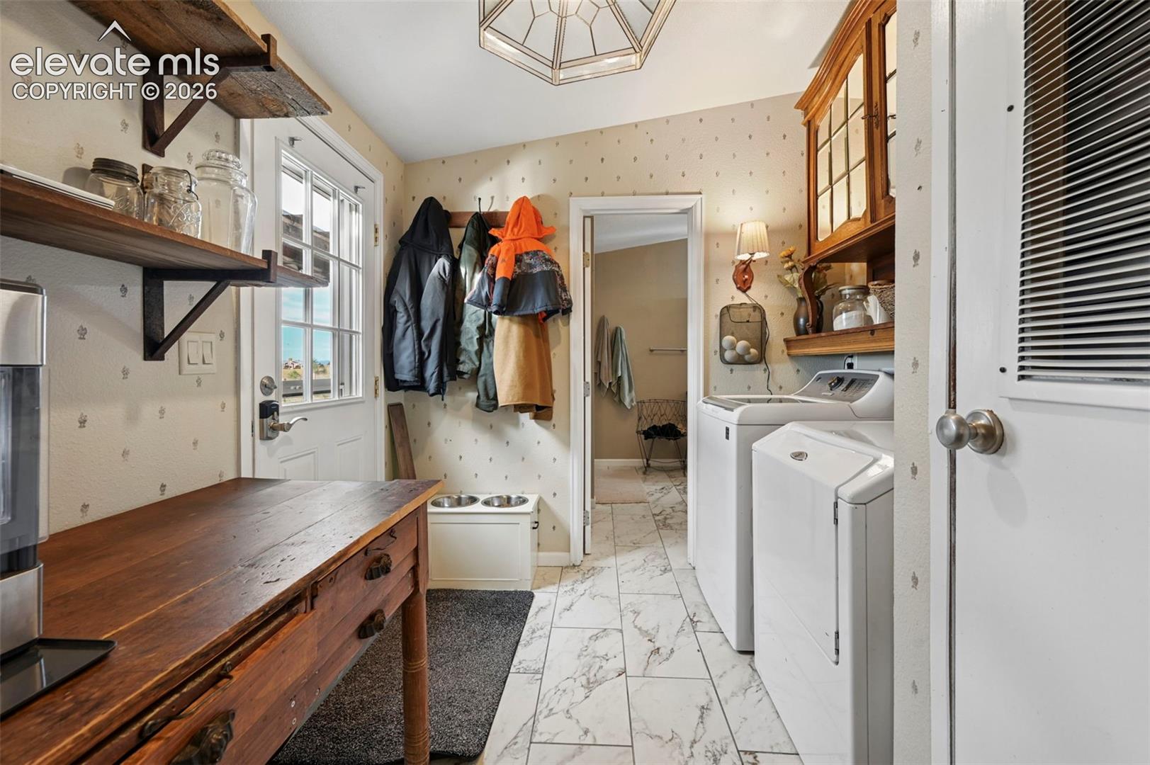 Utility room featuring tile flooring, built-in wooden cabinetry, floating shelving, and an exterior door with glass panes