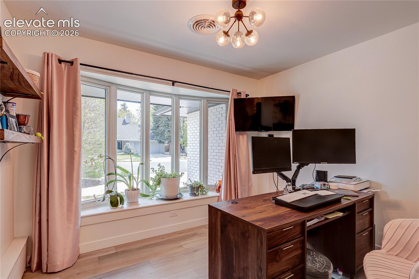 Bay window with a deep sill and light wood-finish flooring
