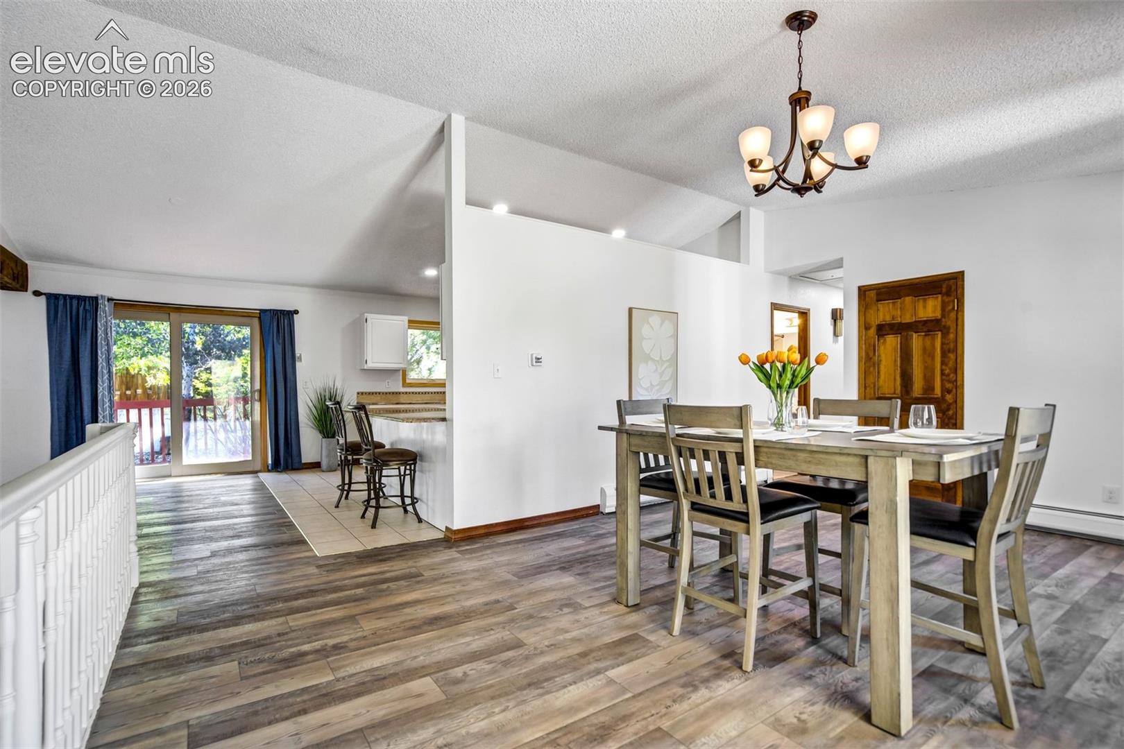 Dining area featuring wood-finish flooring and a contemporary chandelier