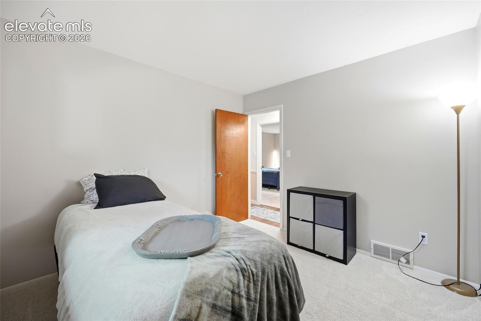 Neutral-toned walls, wall-to-wall carpeting, and wood-finish interior door