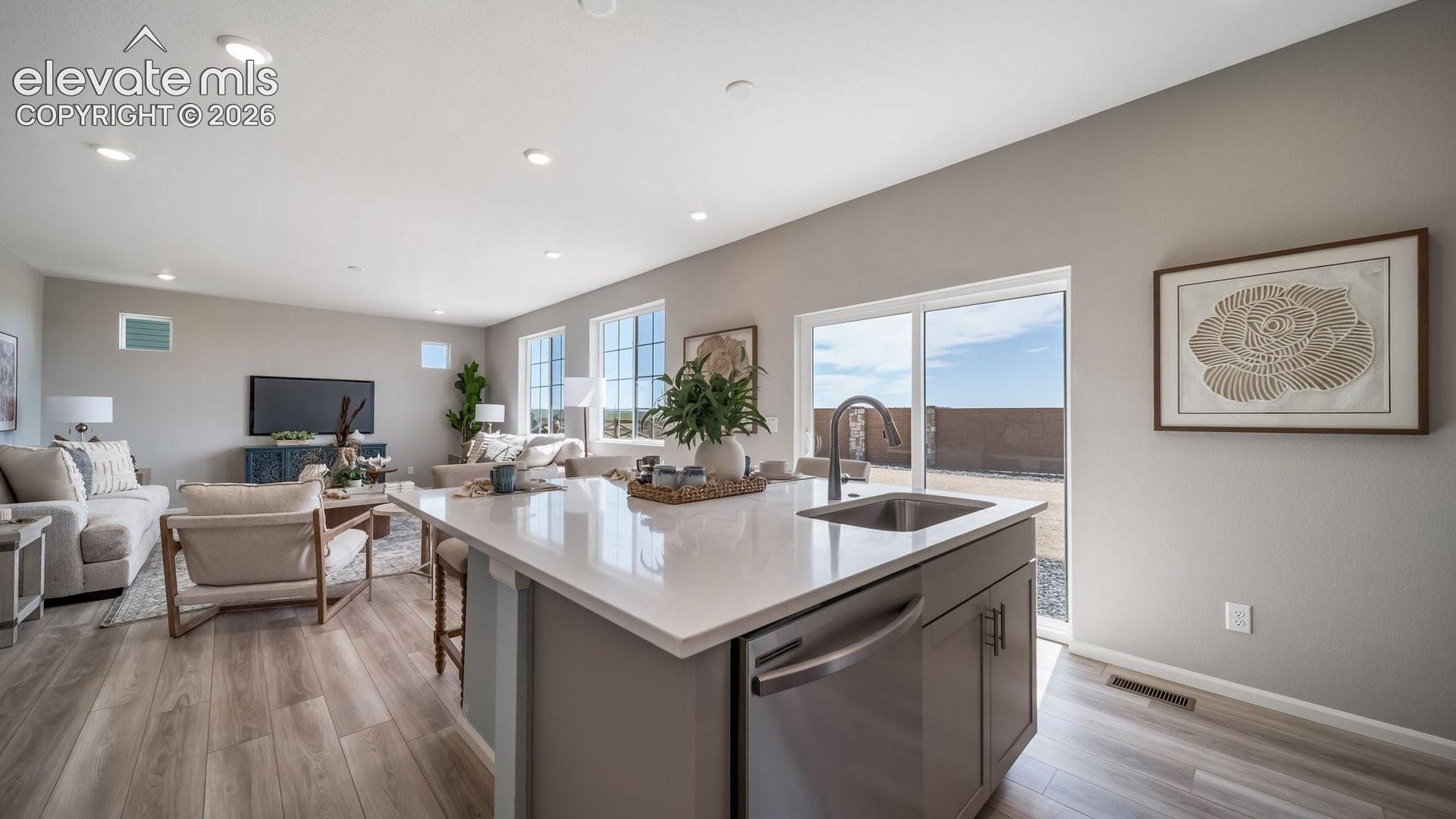 Open concept living space with wood-finish flooring, recessed lighting, and ample natural light from multiple windows
*photos of a model home*