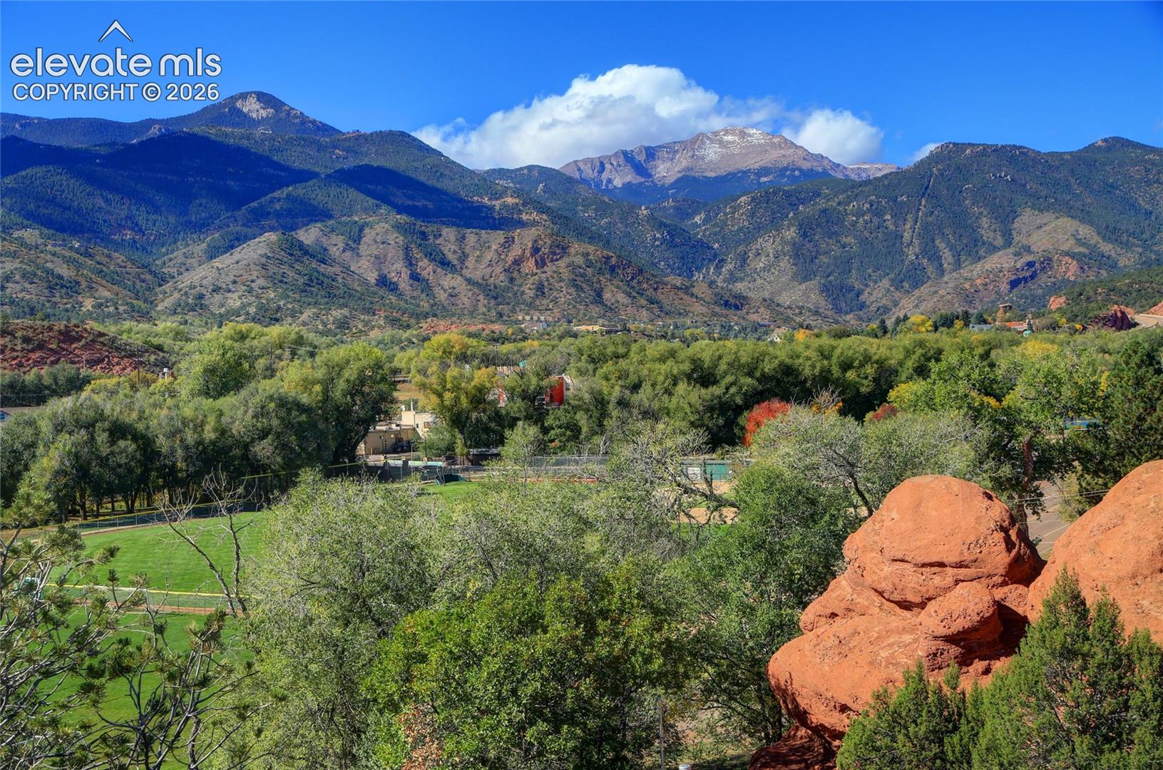 Expansive grounds featuring native red rock formations, mature trees, and mountainous terrain