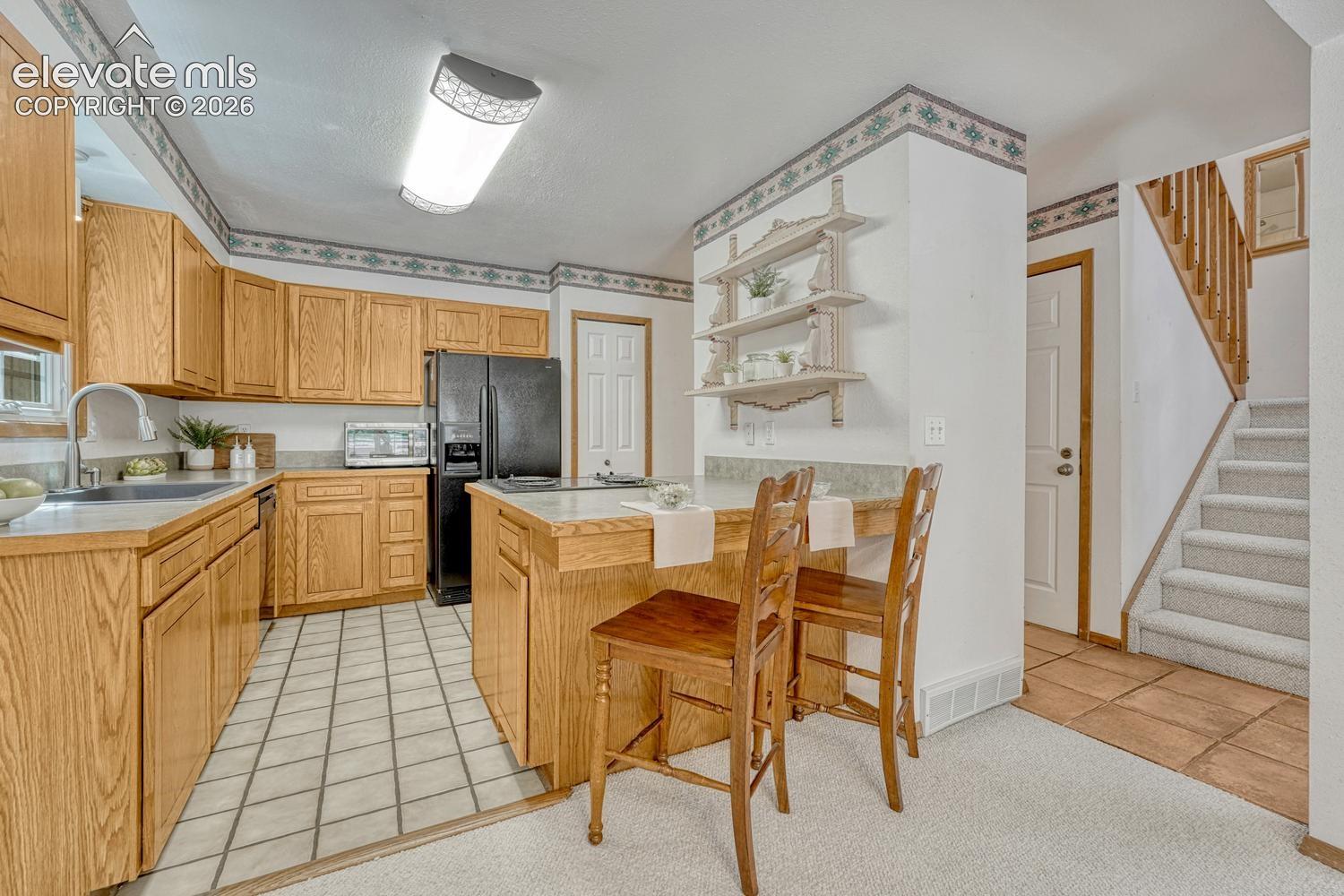 The cheerful kitchen features oak cabinetry, generous counter space, custom shelving, 2 pantries, and a breakfast bar. 