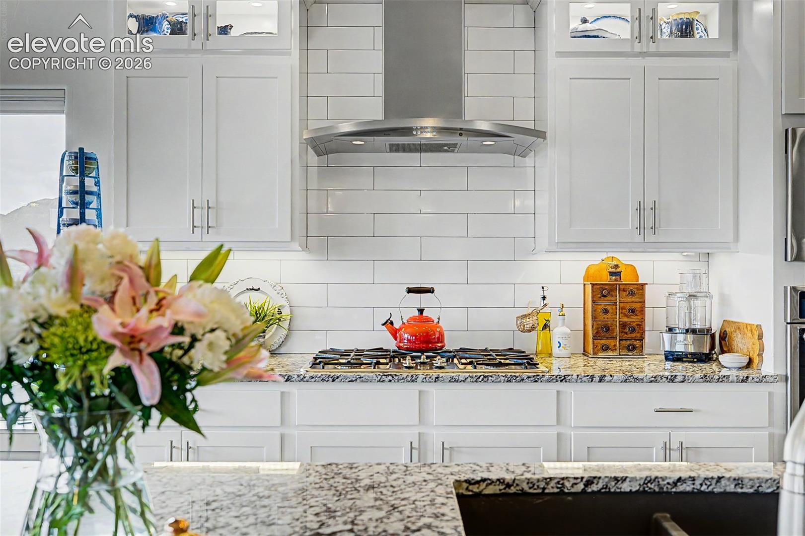 Gorgeous subway tiling, custom hooded vent, and a great gas stove top!