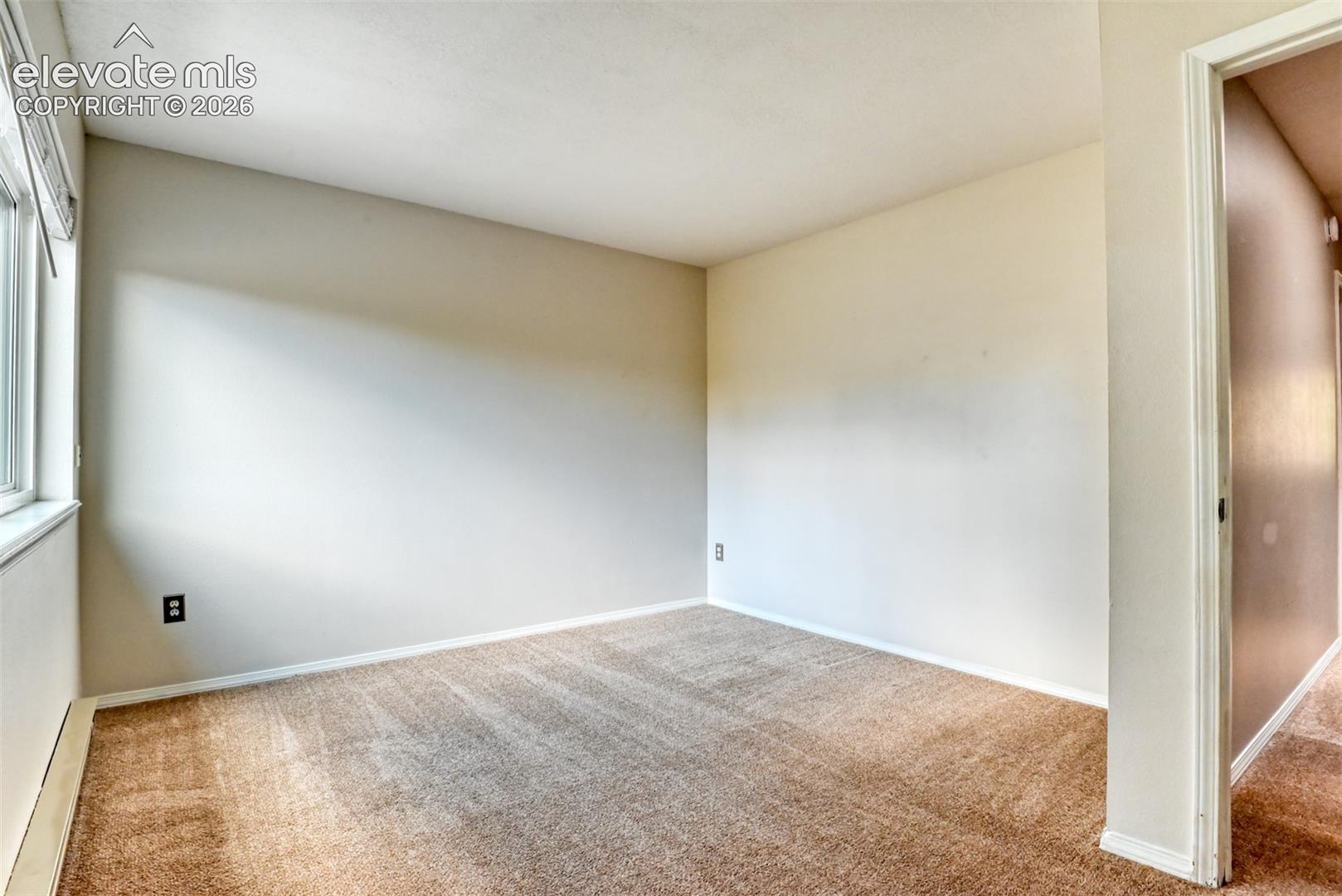Carpeted room with a white window frame, light-colored walls, and a white ceiling