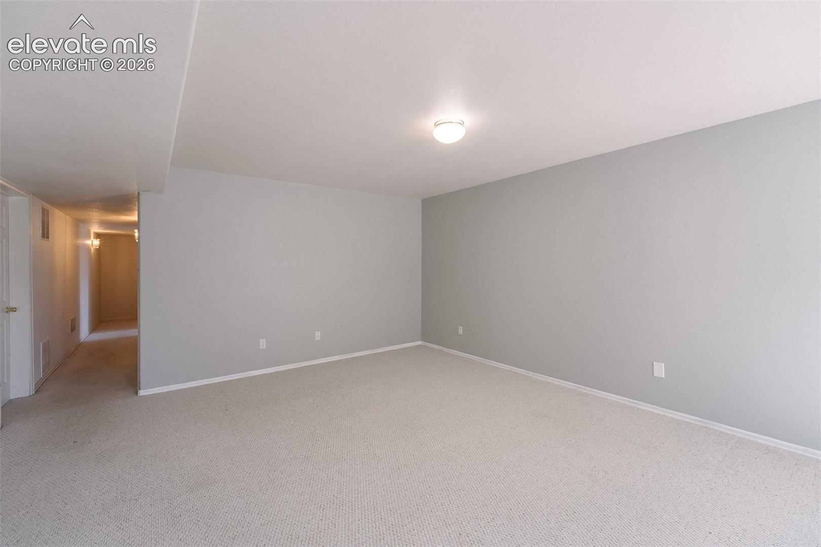Basement Family Room with hallway to the Bedrooms and Basement Bathroom.