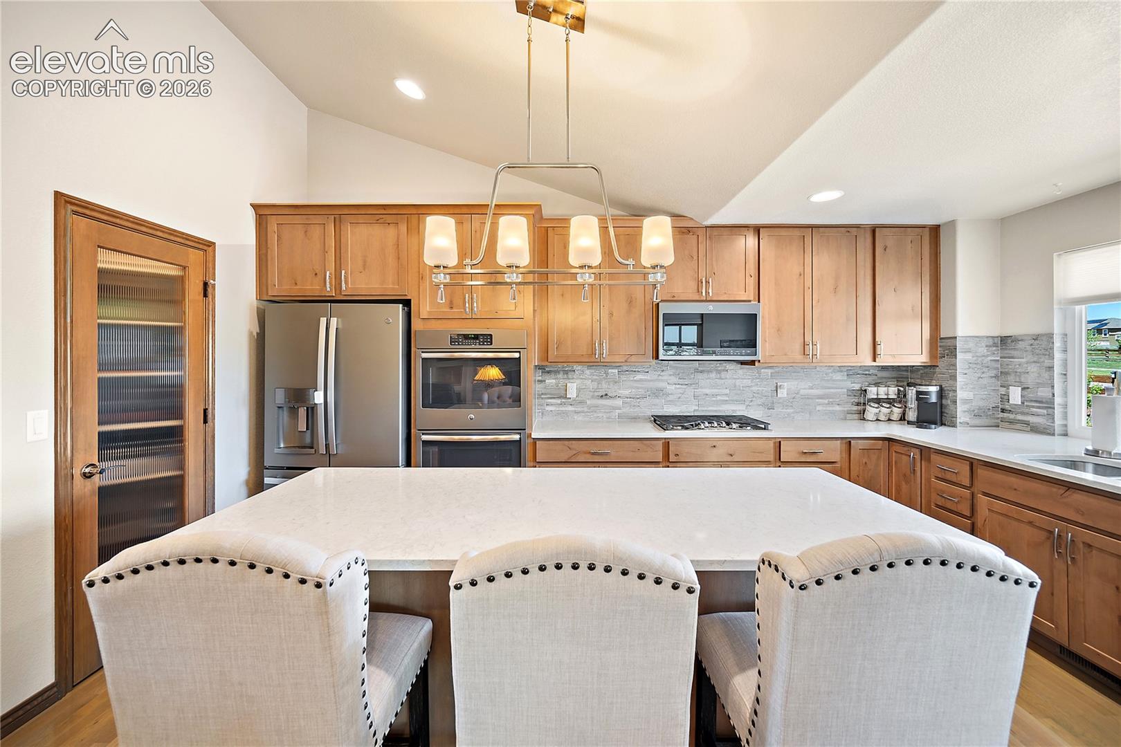 Gourmet kitchen with double oven, gas range, quartz, walk-in pantry and vaulted ceilings. 