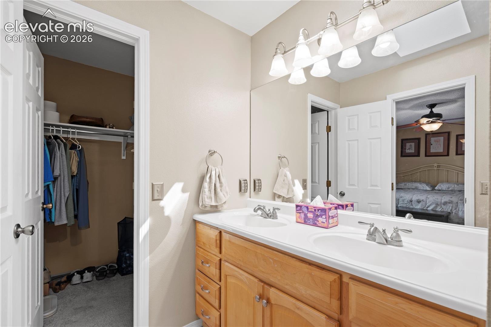 Dual vanity with integrated sinks, wood-finish cabinetry, and brushed nickel faucets