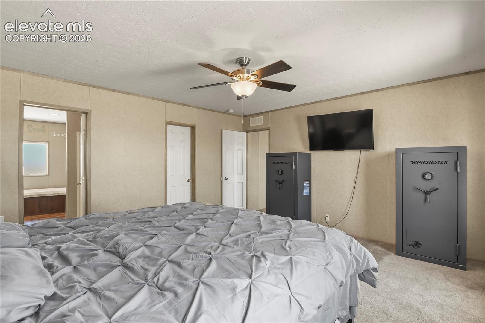 Neutral wall finishes, carpeted flooring, and a central ceiling fan with integrated lighting
