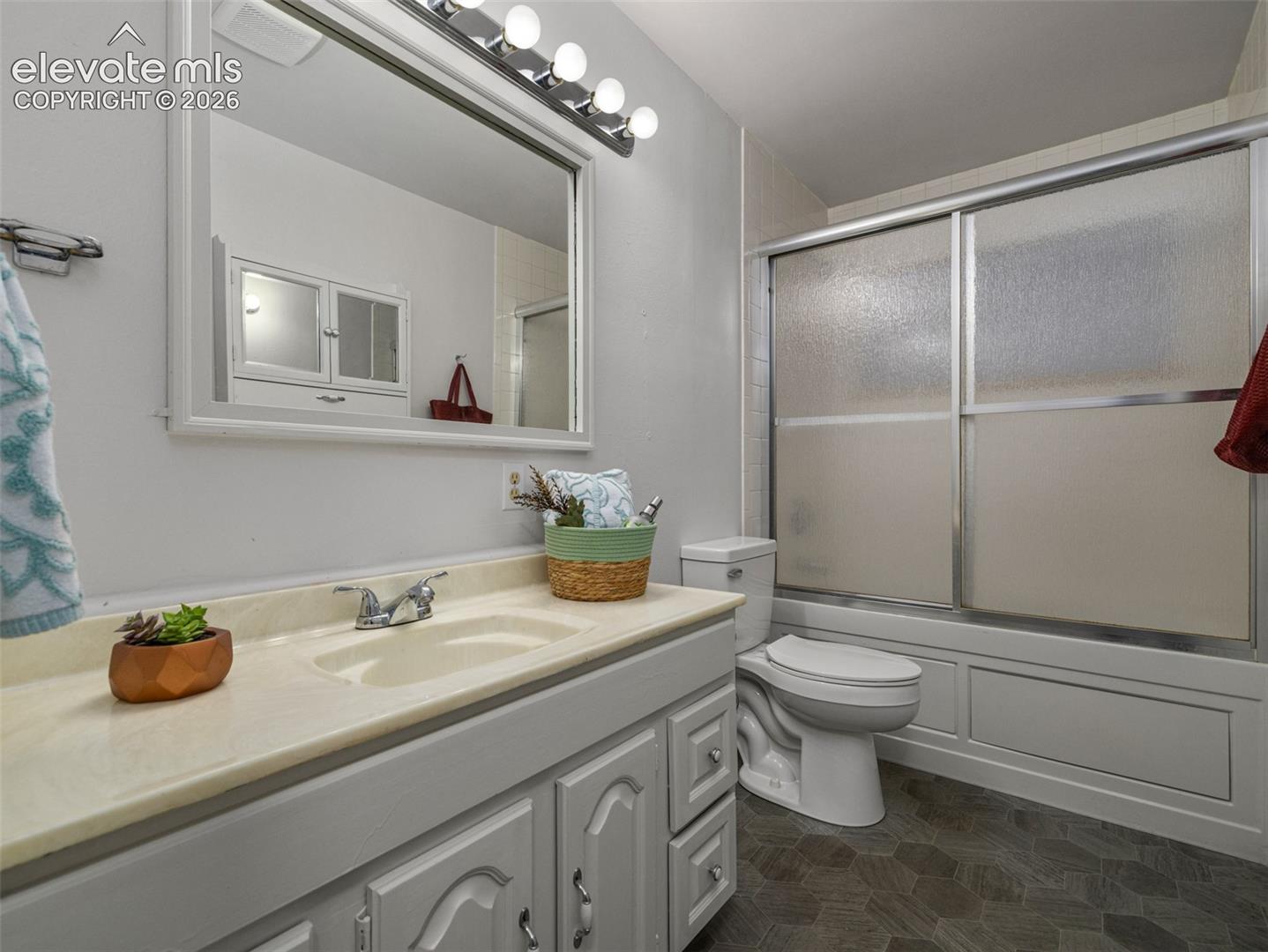 Full bath with jetted tub, Vanity with integrated sink, chrome faucet, and overhead lighting